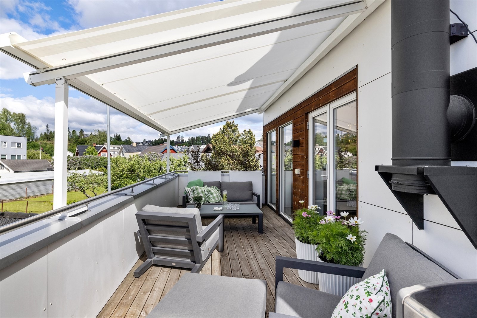 På terrassen utenfor kjøkkenet kan morgenkaffen nytes. Her er det montert en elektrisk markise for solskjerming. Galleribilde