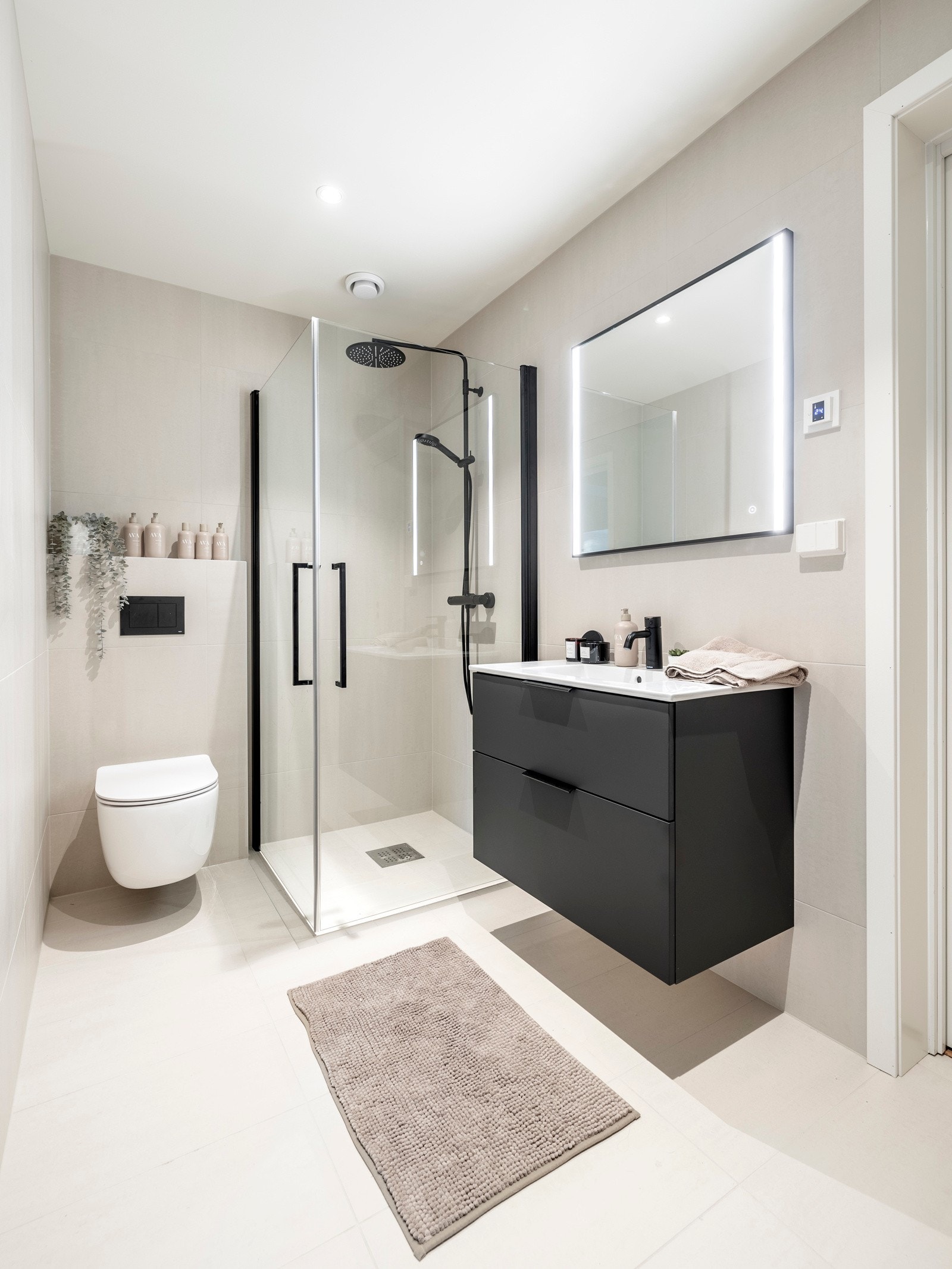 Badet i første etasje er pent innredet med downlights, store vegg- og gulvfliser i grå toner og behagelige varmekabler i gulvet. Galleribilde