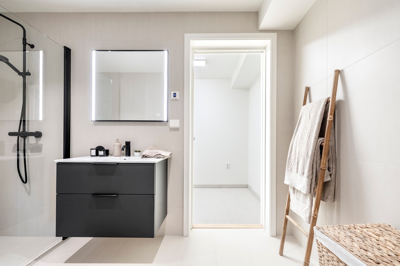 Badet er innredet med servantinnredning, speil på vegg over servant, vegghengt toalett og dusjhjørne med svingbare glassdører. Galleribilde