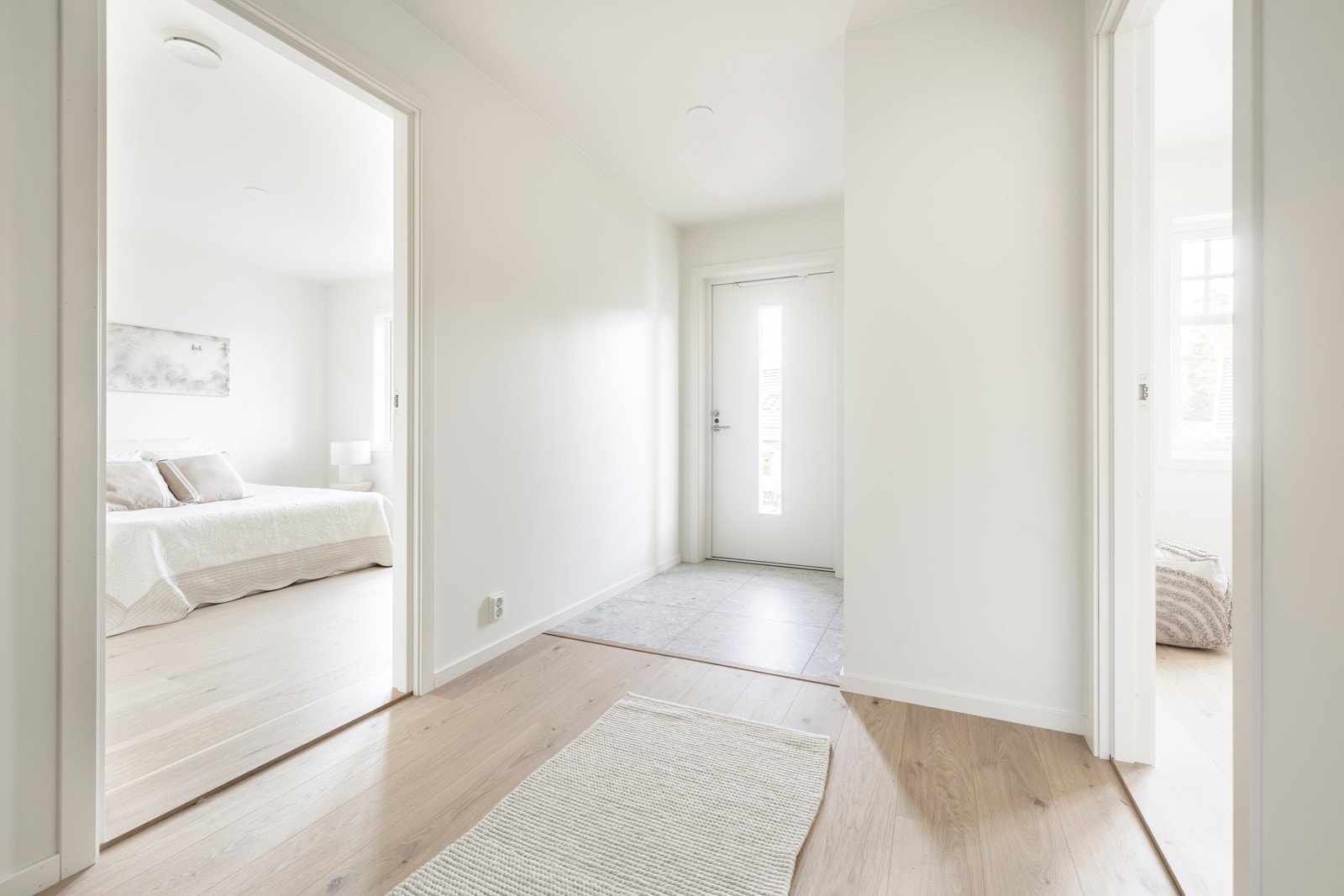 Veggene er holdt i lyse, nøytrale farger og det er store fliser med varmekabler i grå nyanser på gulvet. Galleribilde