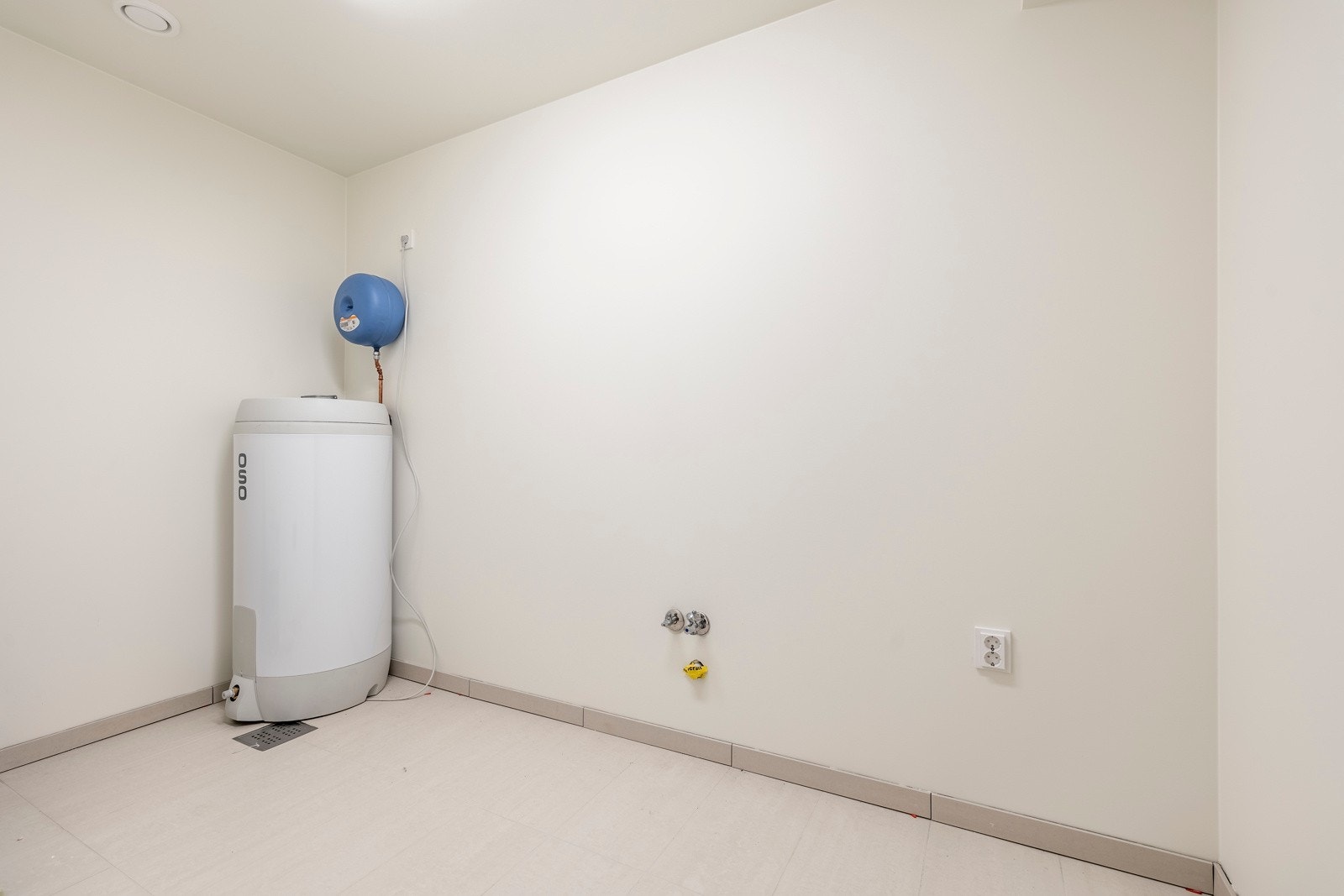 Vaskerommet har fliser på gulvet med varmekabler, mens de lysmalte veggene gir et rent og ryddig uttrykk Galleribilde