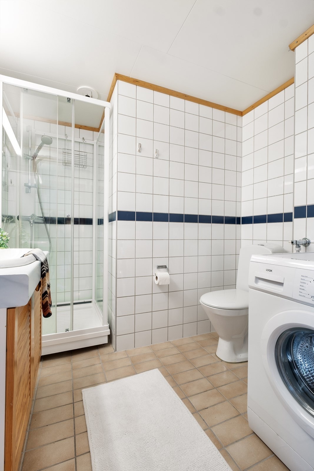 IInnredning med skap og nedfelt servant, toalett, dusjkabinett og opplegg for vaskemaskin. Galleribilde