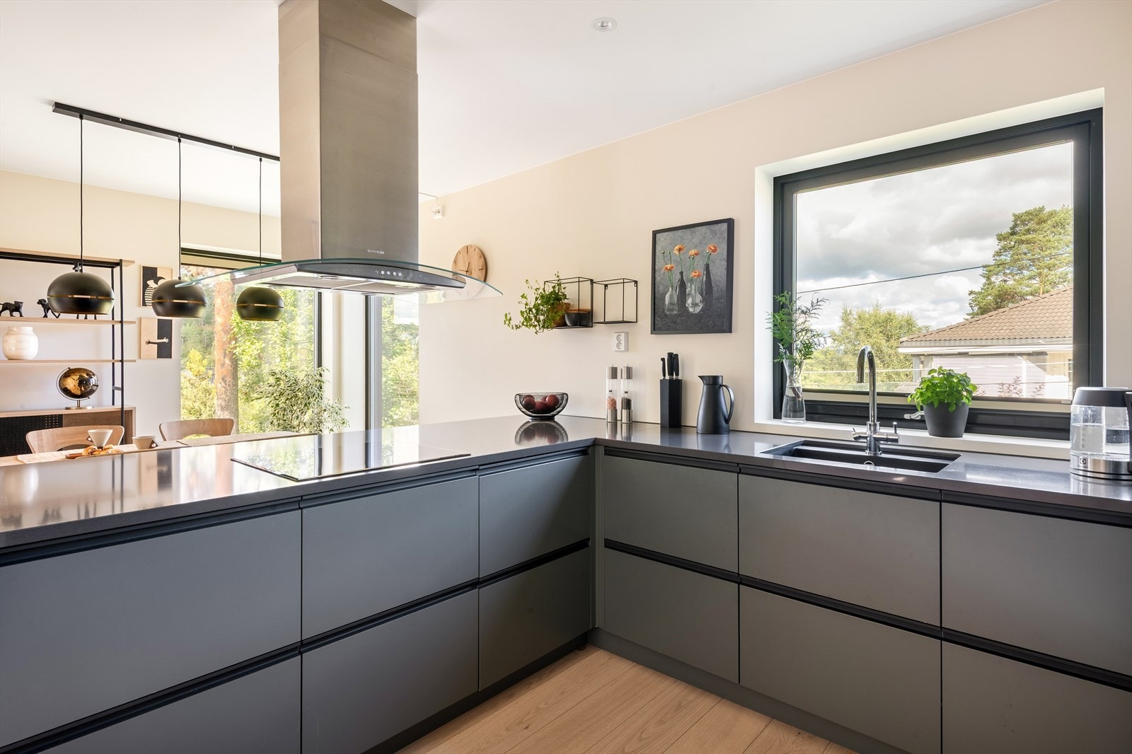 Kjøkkeninnredningen er levert av Drømmekjøkkenet og har glatte, moderne fronter kombinert med en elegant støpt benkeplate. Over benkeflatene er det slette, malte veggflater som gir et rent og tidløst uttrykk. Galleribilde