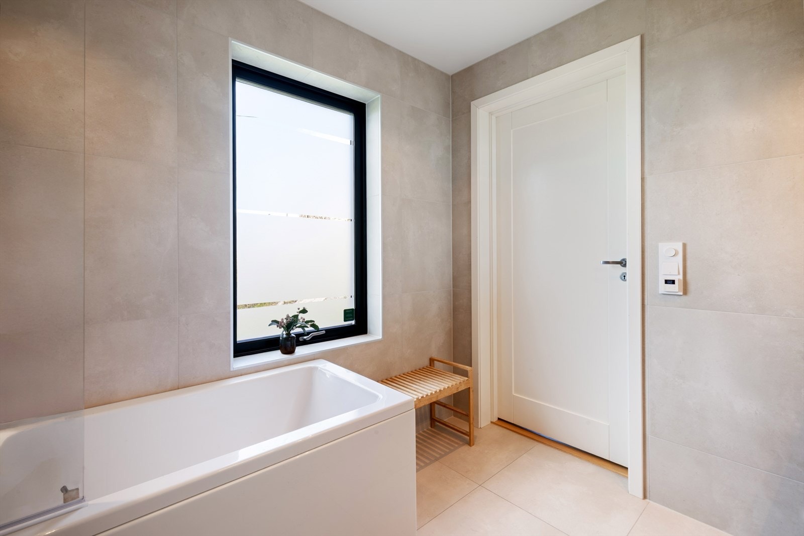 Rommet er innredet med dobbel servant, speilskap med integrert belysning, ettgreps blandebatteri og dusjarmatur. Et frittstående badekar gir rommet en eksklusiv touch og inviterer til avslapning. Galleribilde