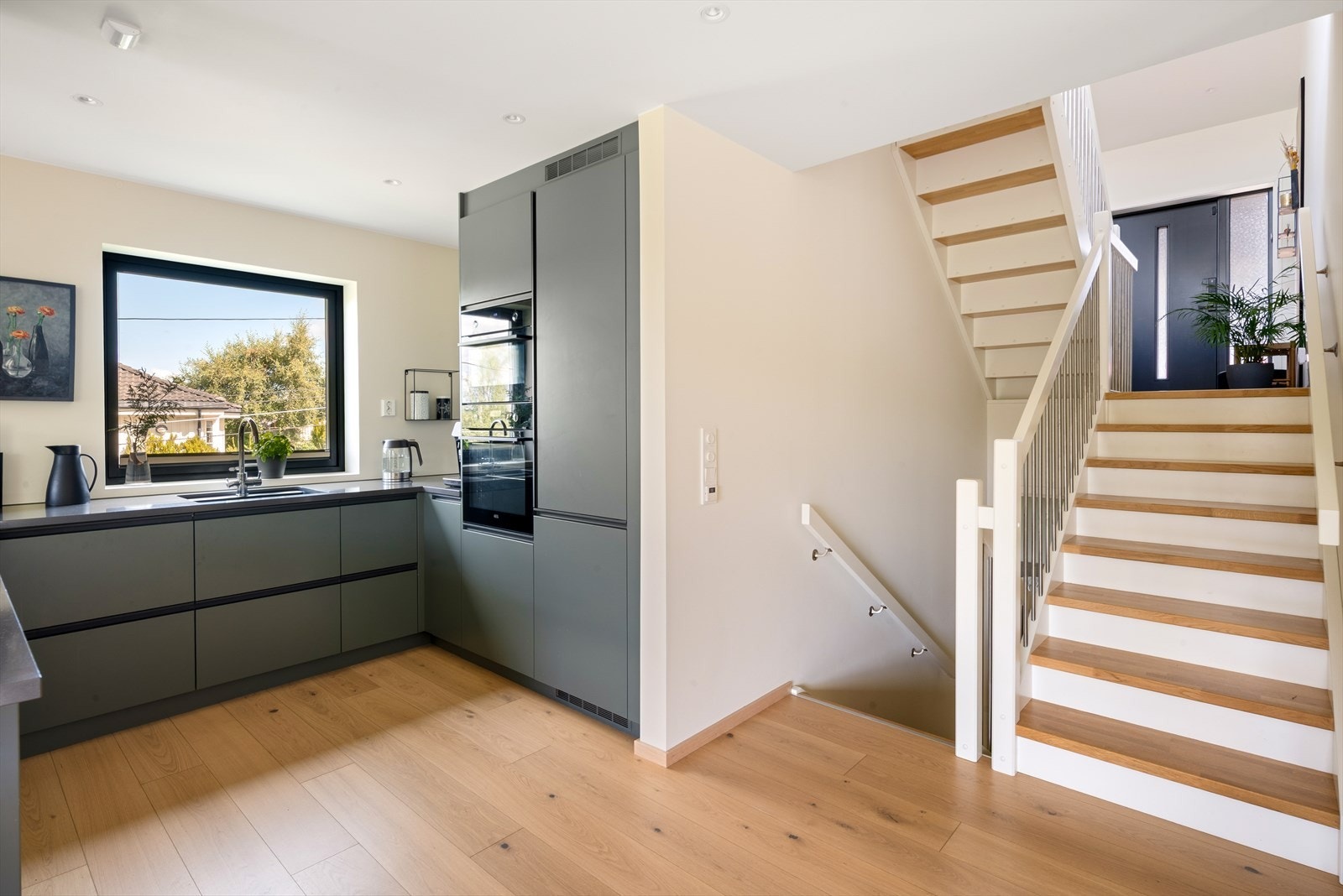 Moderne og stilrent kjøkken i åpen løsning mot stuen, som skaper en sosial og innbydende atmosfære. Galleribilde