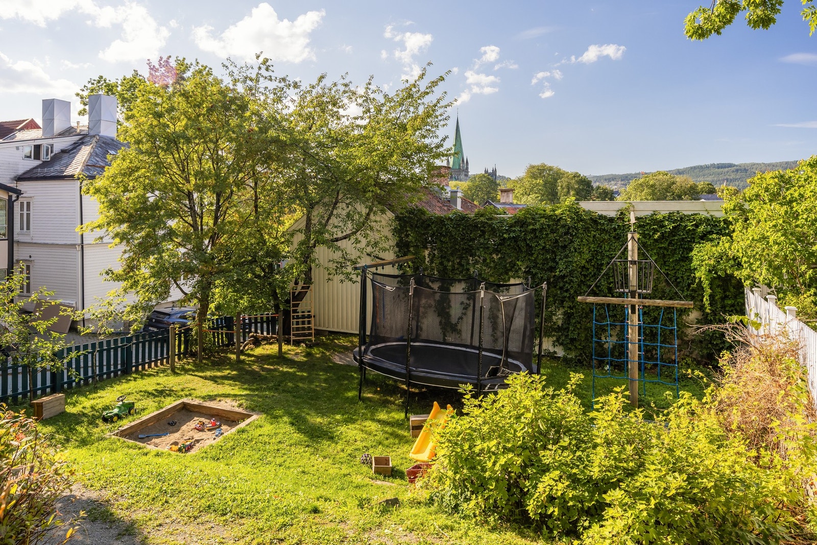 Boligen grenser mot en liten lekeplass på baksiden.