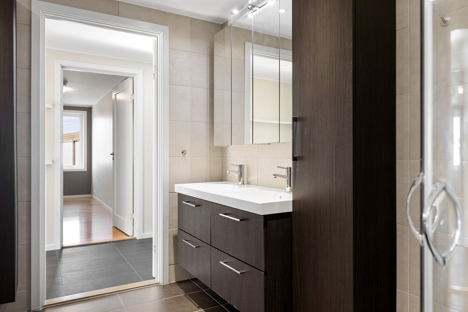 Lyst og moderne baderom med stilrene detaljer og dobbel servant Galleribilde