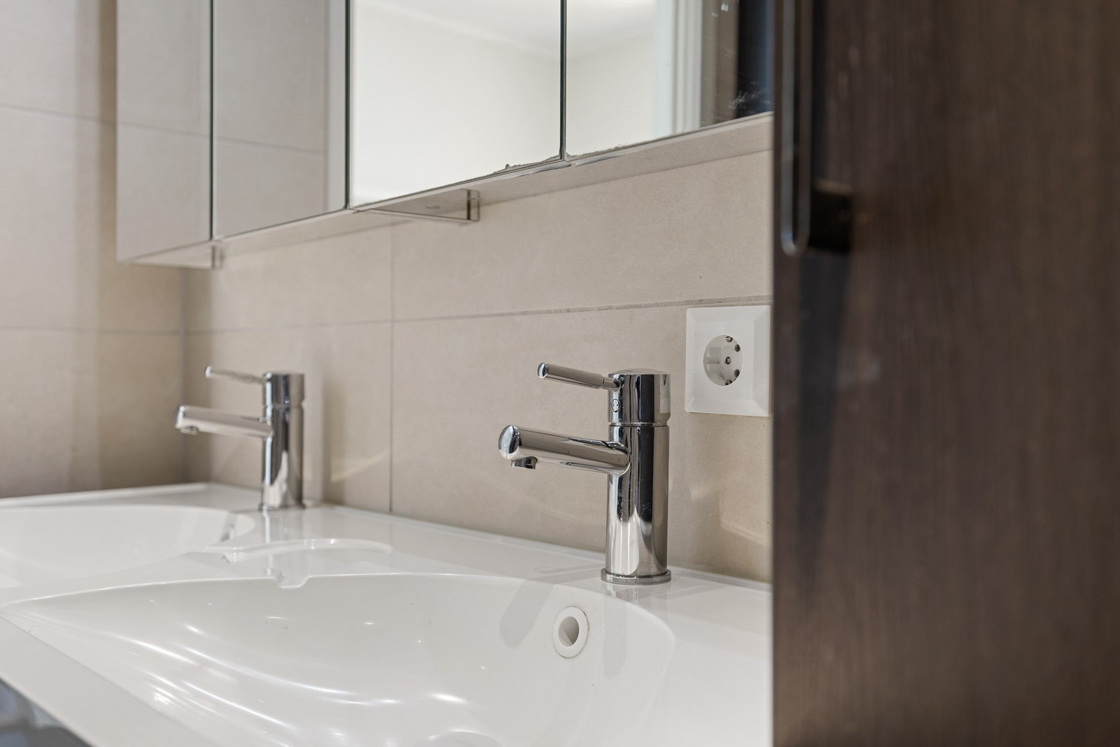 Lyst og moderne baderom med stilrene detaljer og dobbel servant Galleribilde