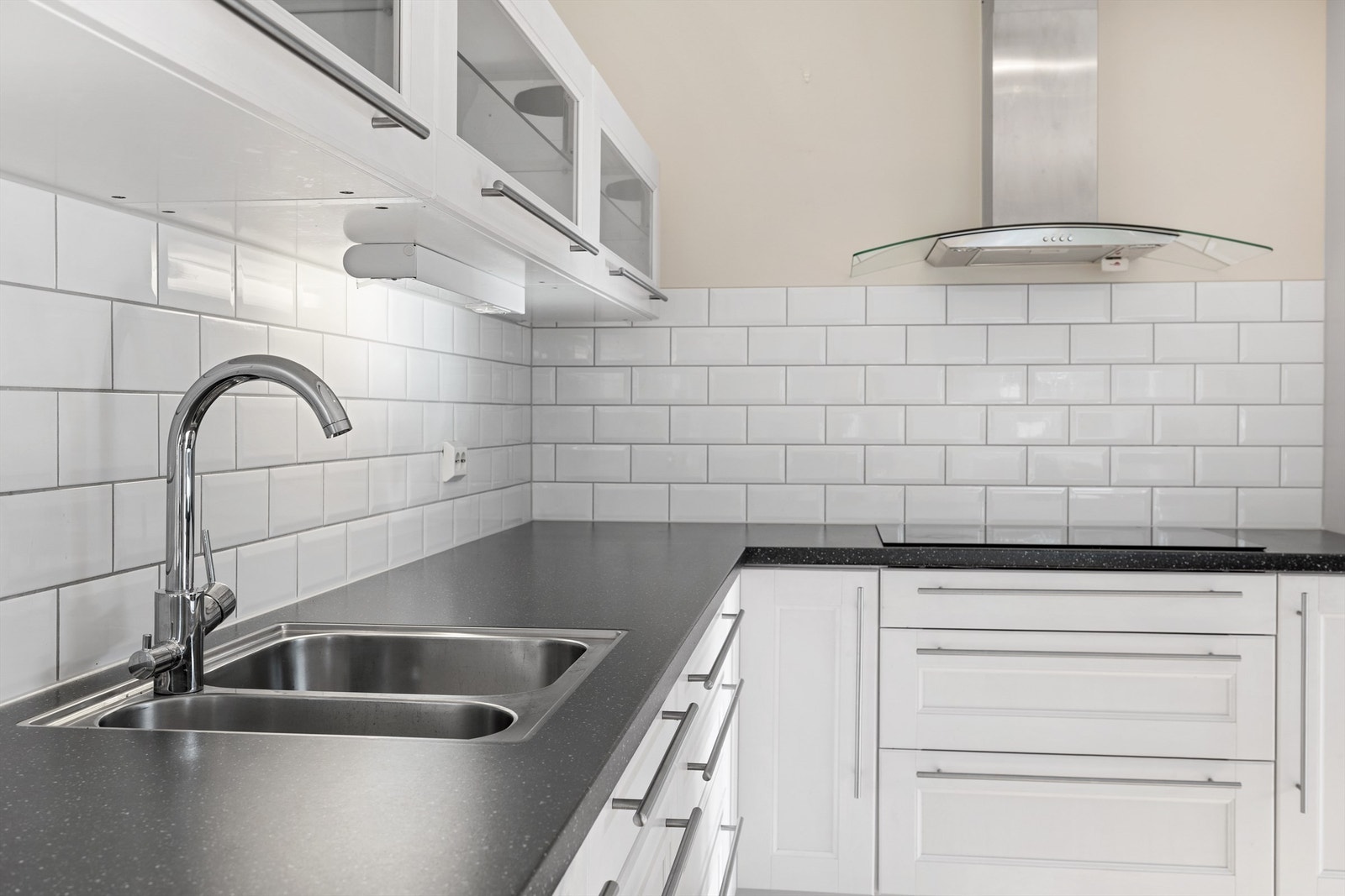 Lys kjøkkenløsning med god benkeplass og stilrene hvite flater Galleribilde