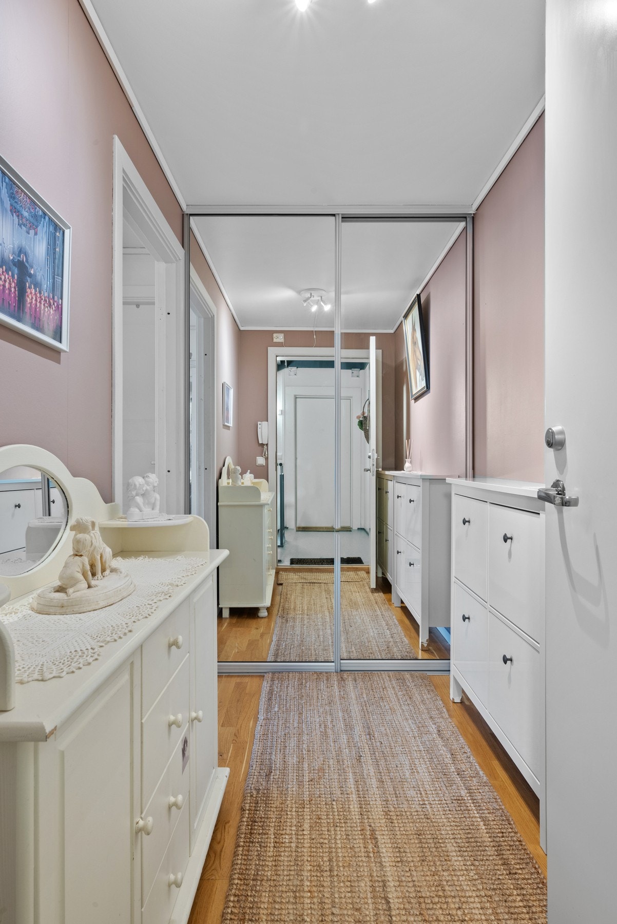 Leiligheten har en romslig entre med skyvedørsgarderobe med glassfronter. Galleribilde