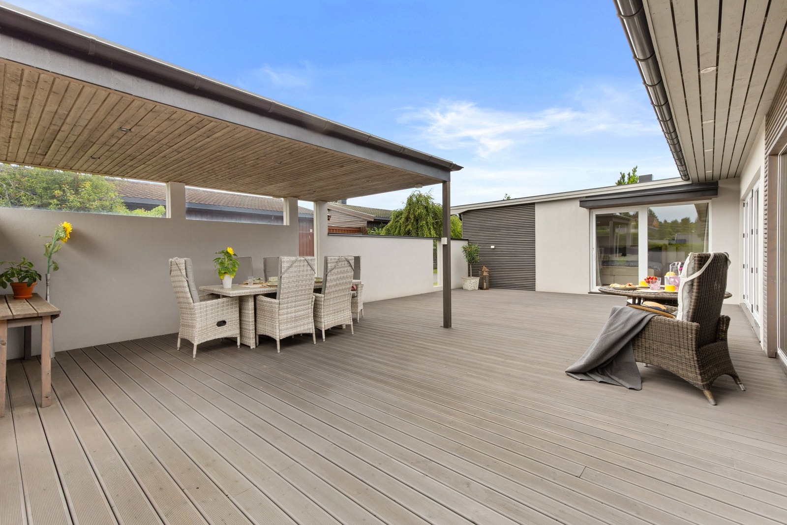 Stor terrasse med flere soner for både spiseplass og loungehjørne. Galleribilde