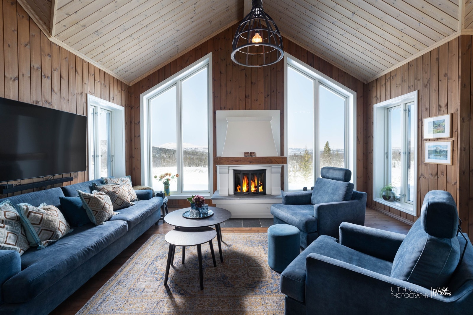 Stor stue med åpen himling, flott peis og panoramavinduer med utsikt til Jotunheimen Galleribilde