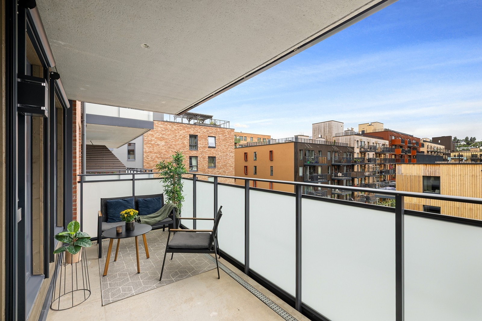 Balkongen vender mot et rolig gårdsrom og har rekkverk i frostet glass som gir både lys og privatliv. Galleribilde