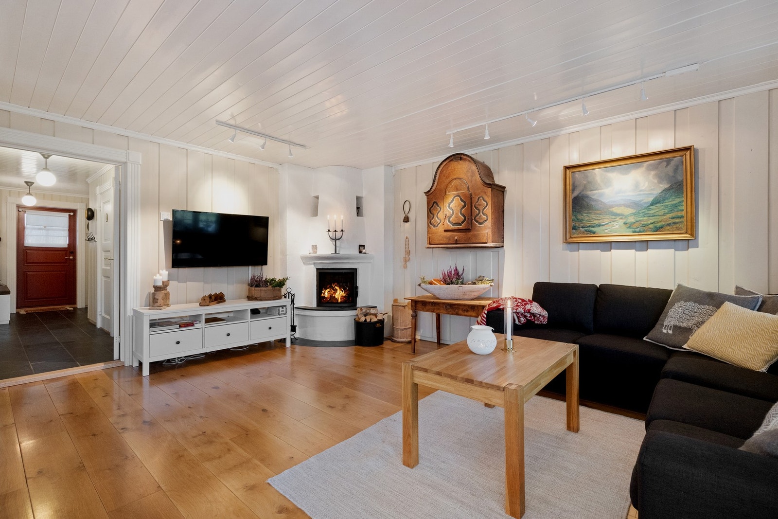 Peisen i hjørnet bidrar til den gode varmen og skaper en hyggelig atmosfære Galleribilde