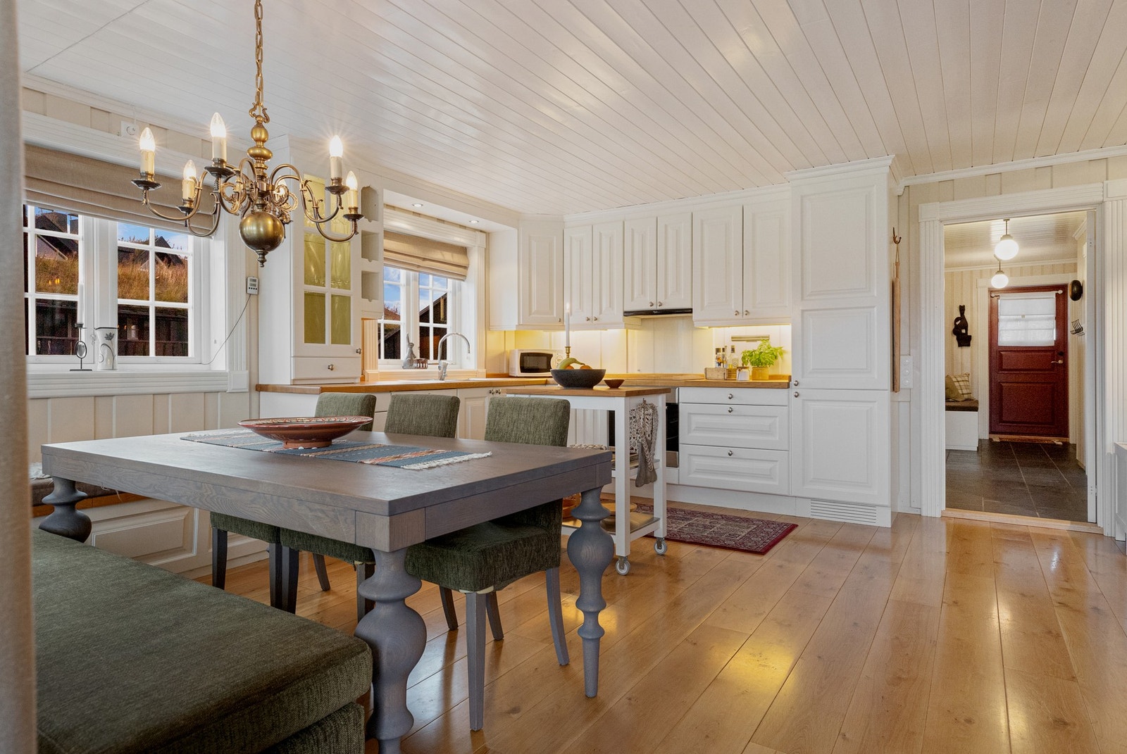 Flott kjøkken med heltre innredning og profilerte fronter, skapene går helt opp til himling Galleribilde