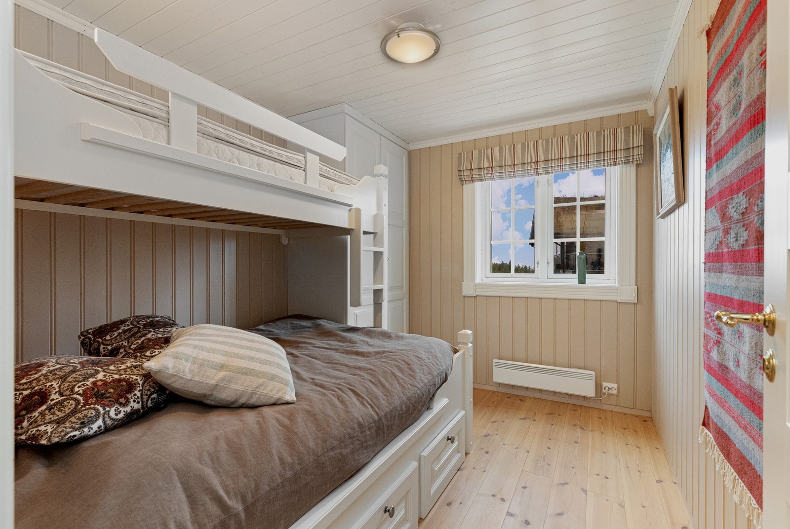 Soverom to med familiekøyeseng som har oppbevaringsskuffer under seng, her er det også garderobeskap Galleribilde