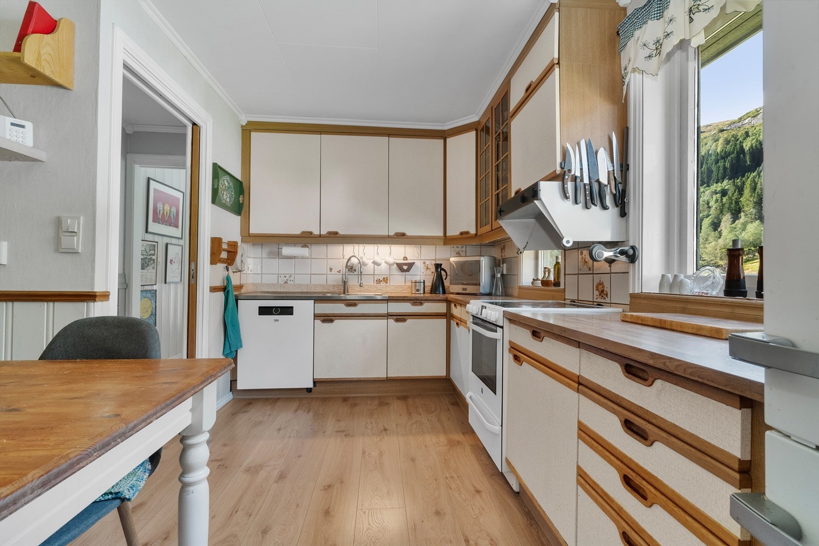 Kjøkkenet har innredning fra byggeår med glatte fronter og benkeplate av laminat Kjøkkenet har godt med skap- og benkplass. Galleribilde