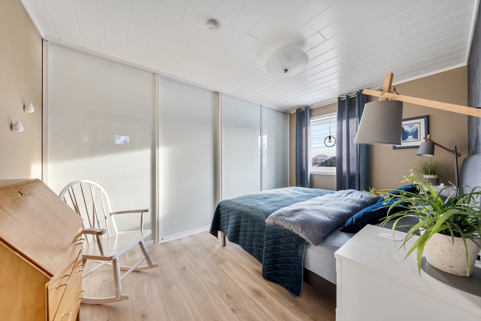 Romslig hovedsoverom med skyvedørsgarderobe fra Leba.