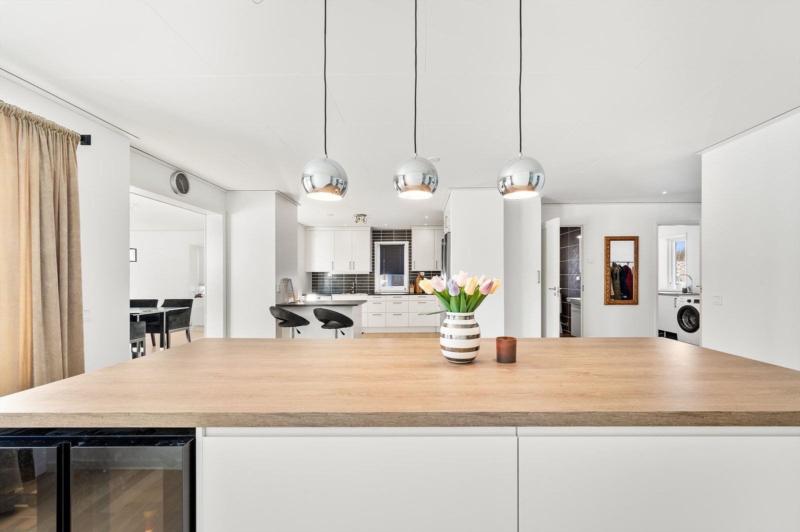 - Et imponerende øydesign som skiller seg ut fra spisestue og kjøkken, med en integrert vinskap som legger til en elegant touch til rommet - Galleribilde