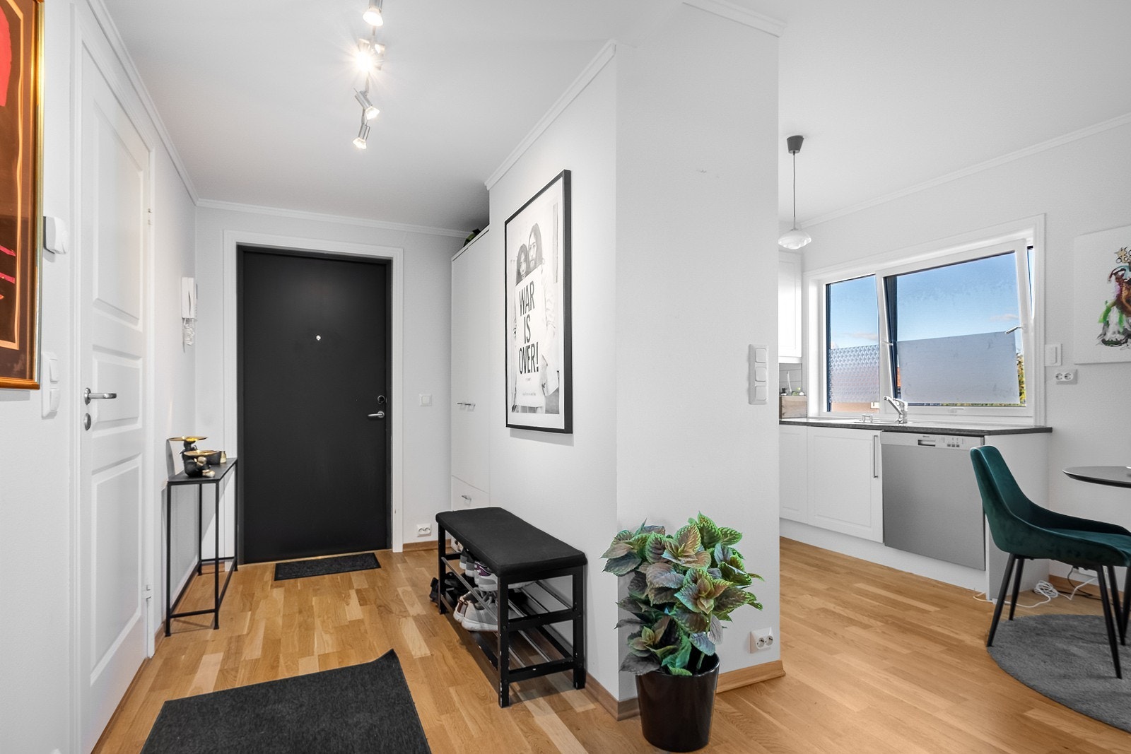 Vel inne i leiligheten møter du en romslig entré med praktisk innebygd nisje for garderobeskap og plass til en sittebenk. Galleribilde