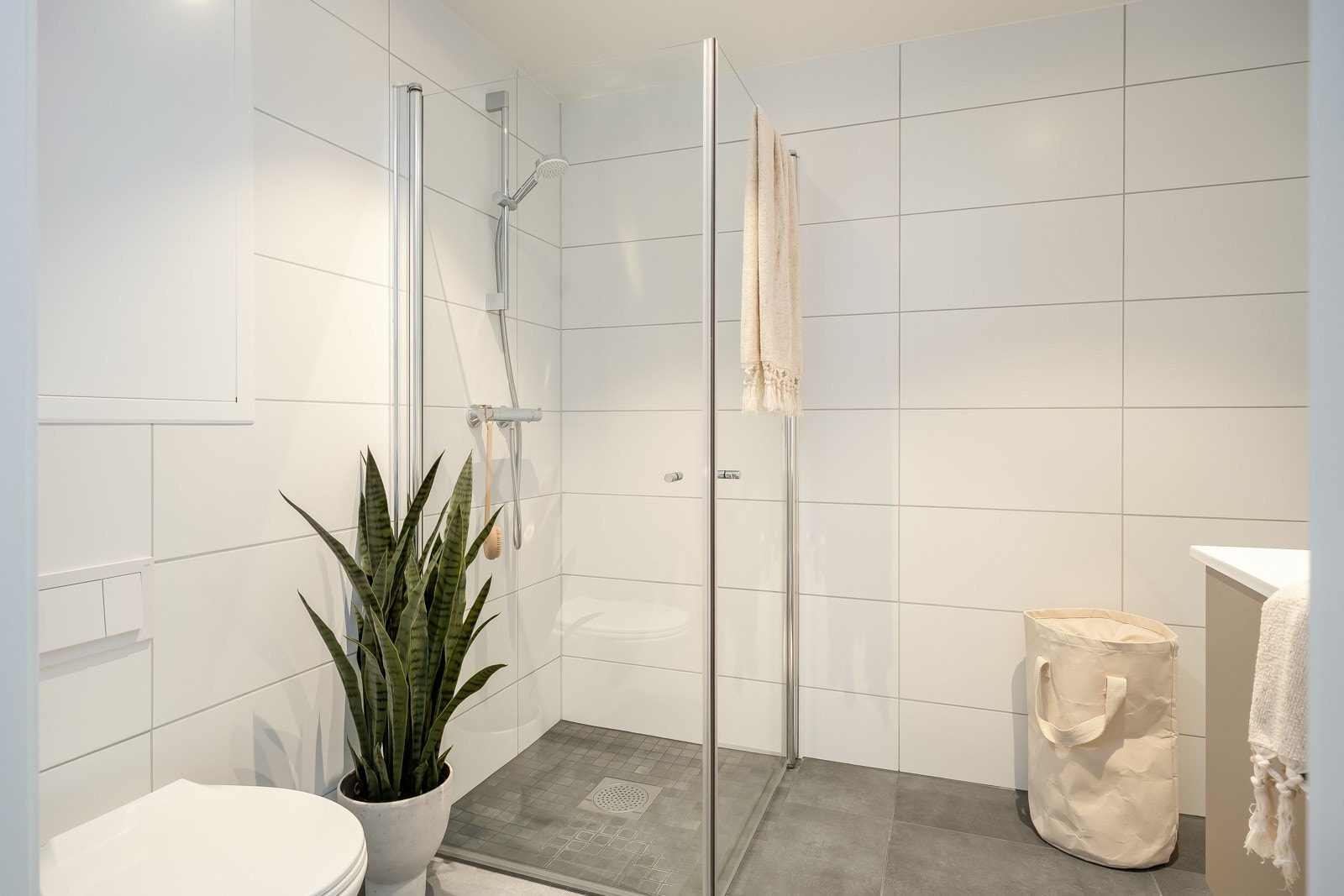 Badet er videre utstyrt med servant med innredning fra HTH, vegghengt toalett og dusjnisje med glassdør. Galleribilde