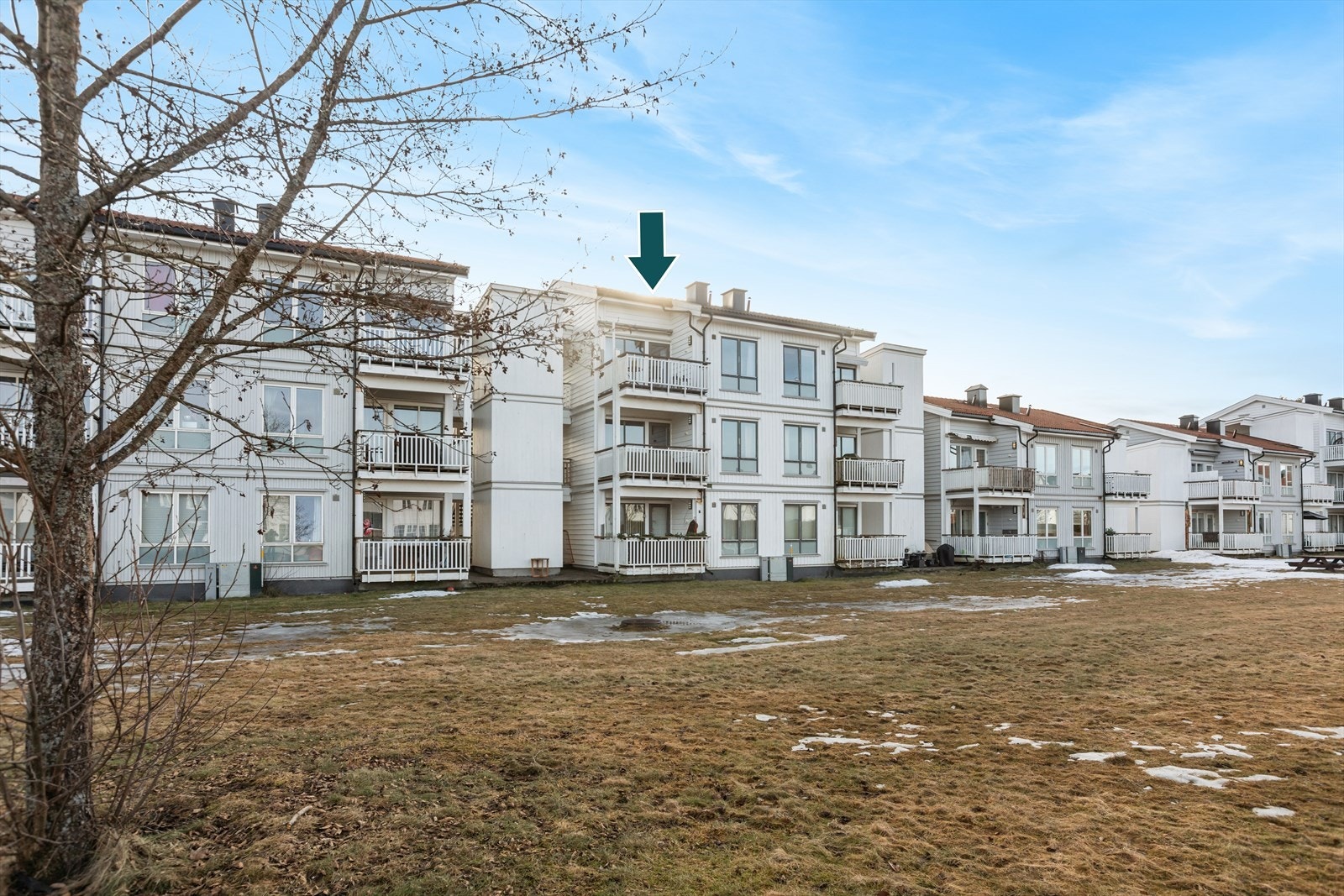 Leilighetens balkong vender ut mot et stort. grønt fellesområde. Galleribilde