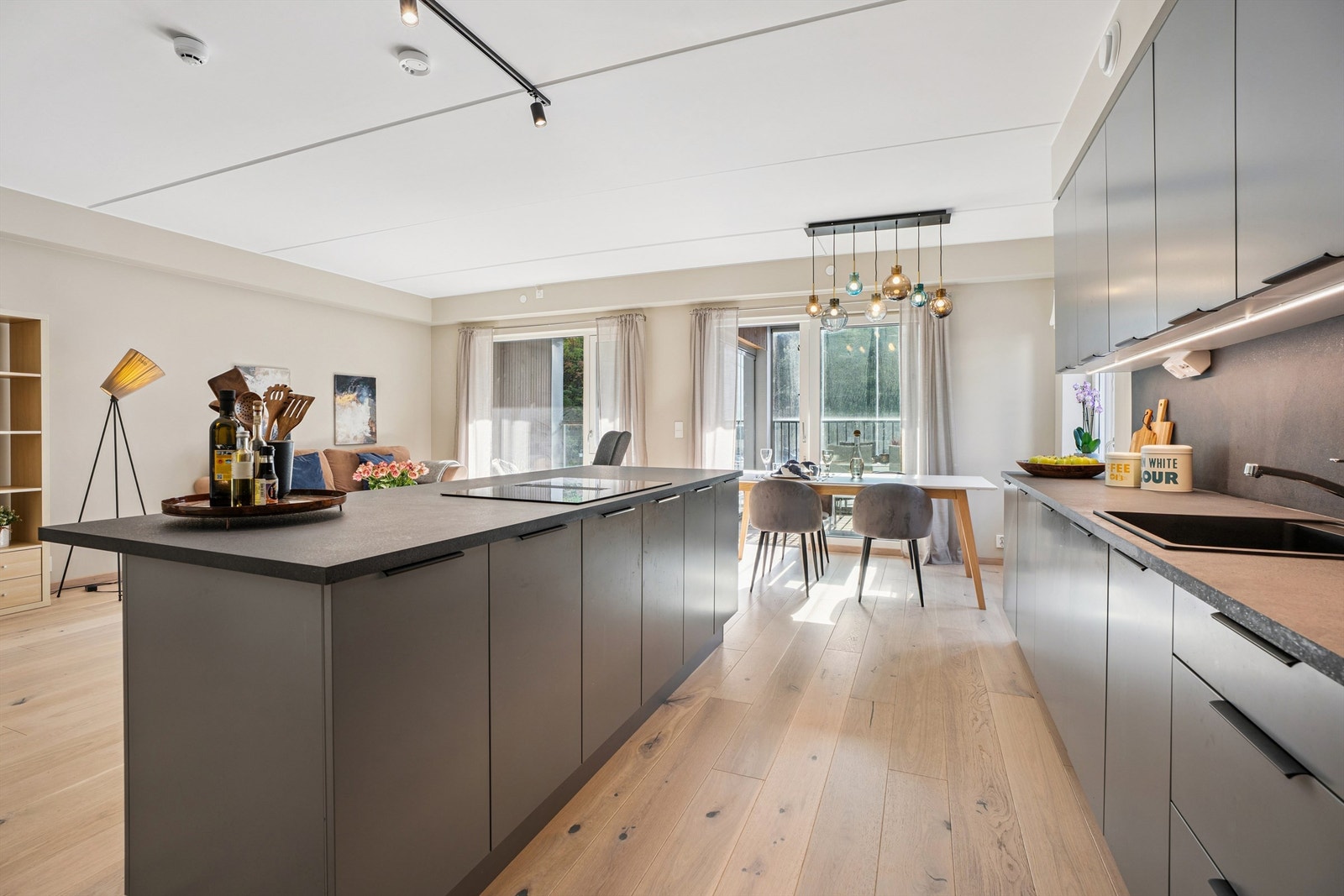 Kjøkkenøyen fungerer som et naturlig samlingspunkt og har integrert ventilator i koketoppen. Galleribilde