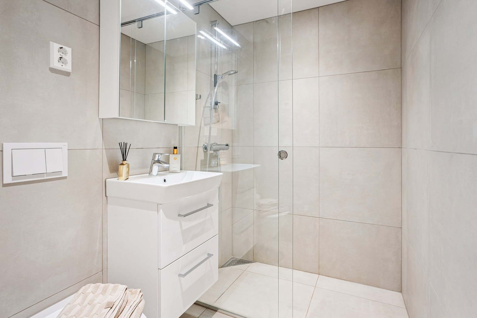 Dette er leilighetens andre bad, like stilrent og utstyrt med dusj og vegghengt toalett. Galleribilde