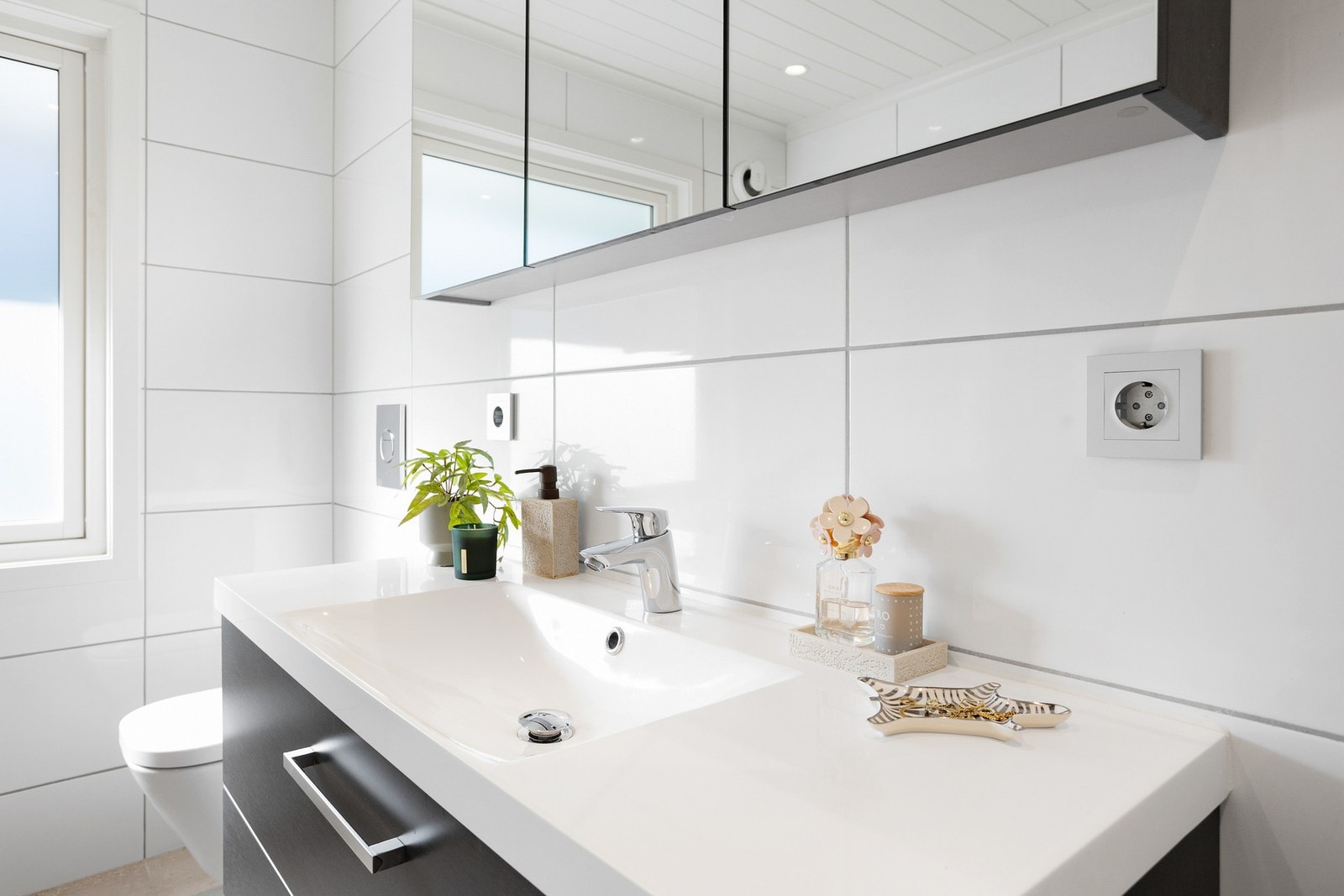 Badet inneholder servant, speilskap, veggmontert wc og dusjkabinett. Meget praktisk med bad/wc i begge etasjer for storfamilien i "morgenrushet". Galleribilde