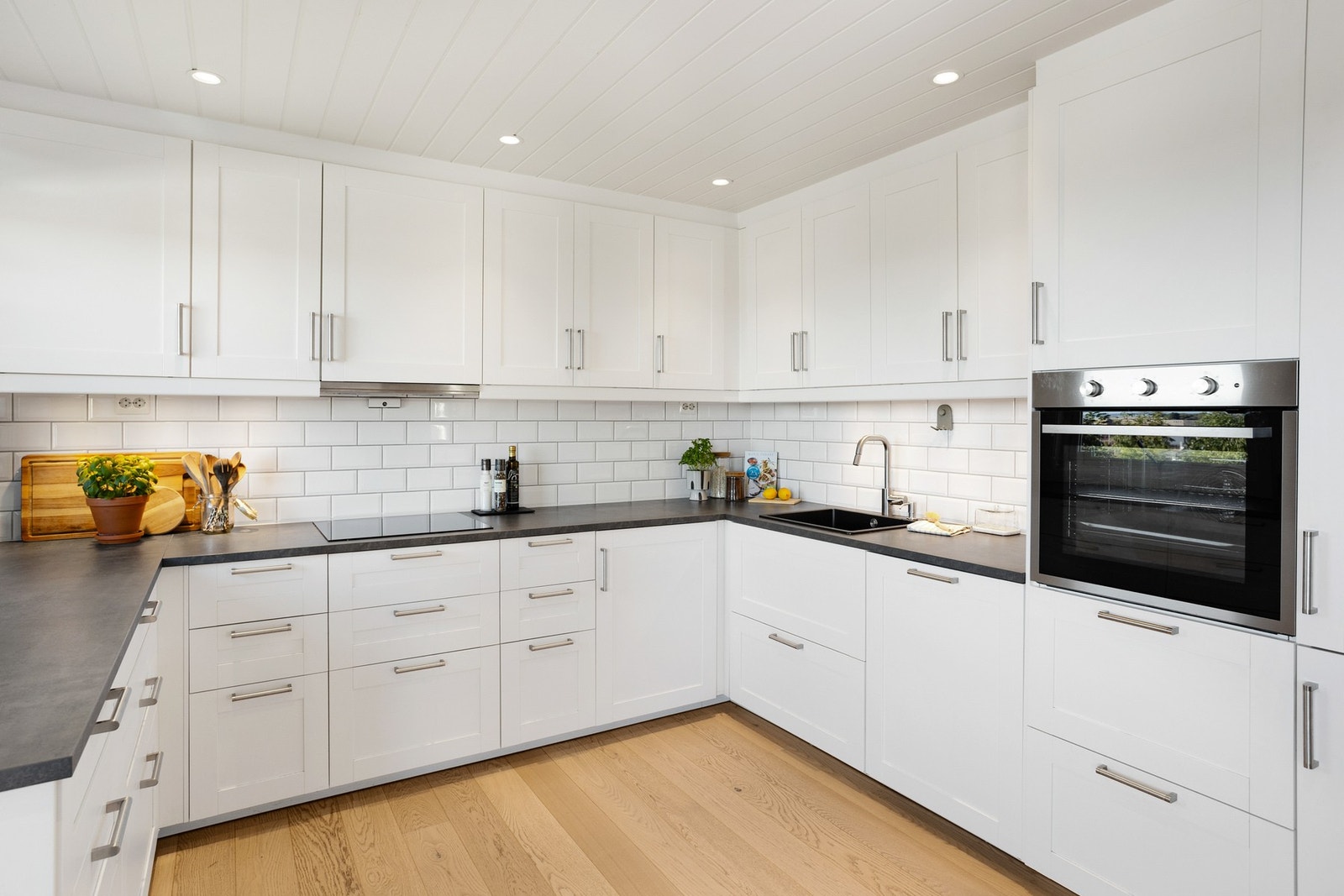 Integrerte hvitevarer som oppvaskmaskin, stekeovn, induksjonstopp og kjøl-/fryseskap. Galleribilde