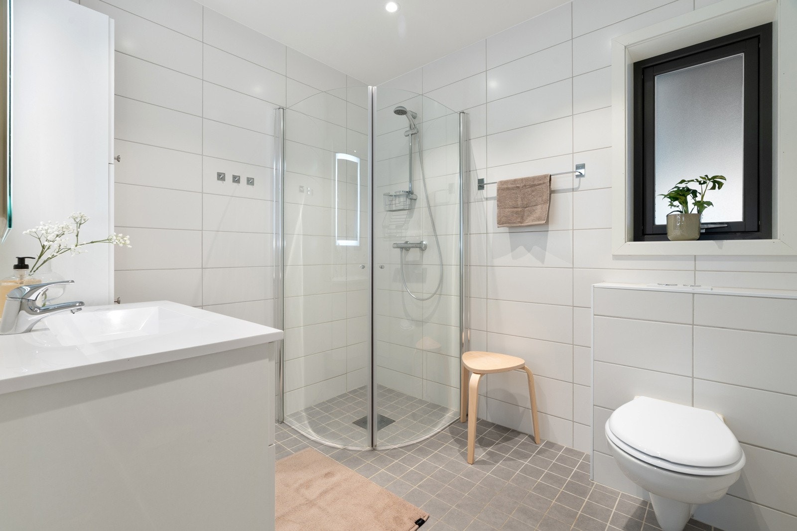 Badet er meget innbydende og er komplett flislagt, og er blant annet utstyrt med downlights og varmekabler i gulv