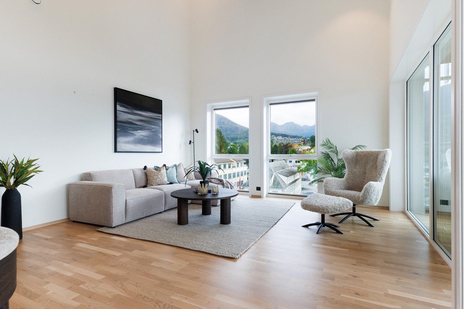 Leiligheten har en lys og stilren innredning med hvitmalte vegger og eikeparkett på gulv Galleribilde