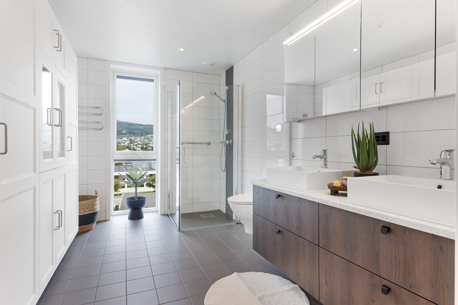 Romslig baderom med fliser på gulv og vegg Galleribilde