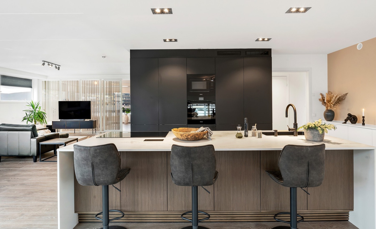 Moderne kjøkken fra 2024 med stilrene, glatte fronter og benkeplate i stein. Galleribilde