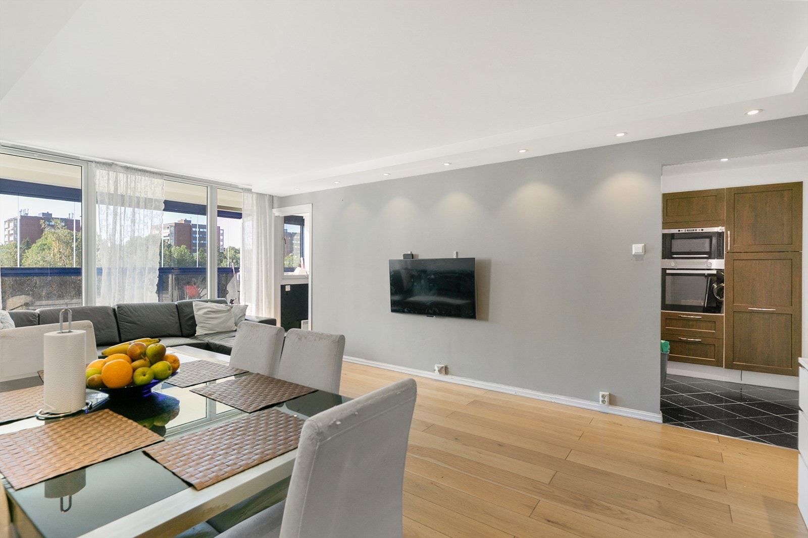 Her ser vi den åpne løsningen mellom stue og kjøkken, som skaper et sosialt og sentralt allrom. Galleribilde