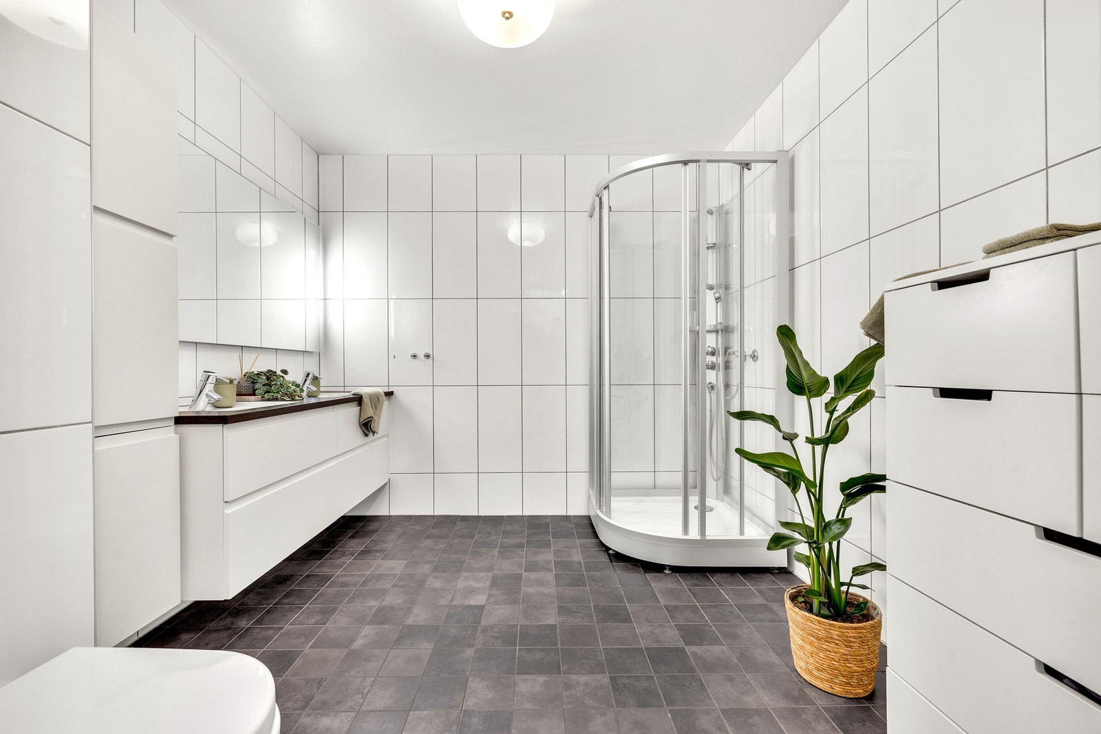 Flott flislagt bad på ca. 7,5 kvm og oppleves som romslig med god lagringsplass. Galleribilde