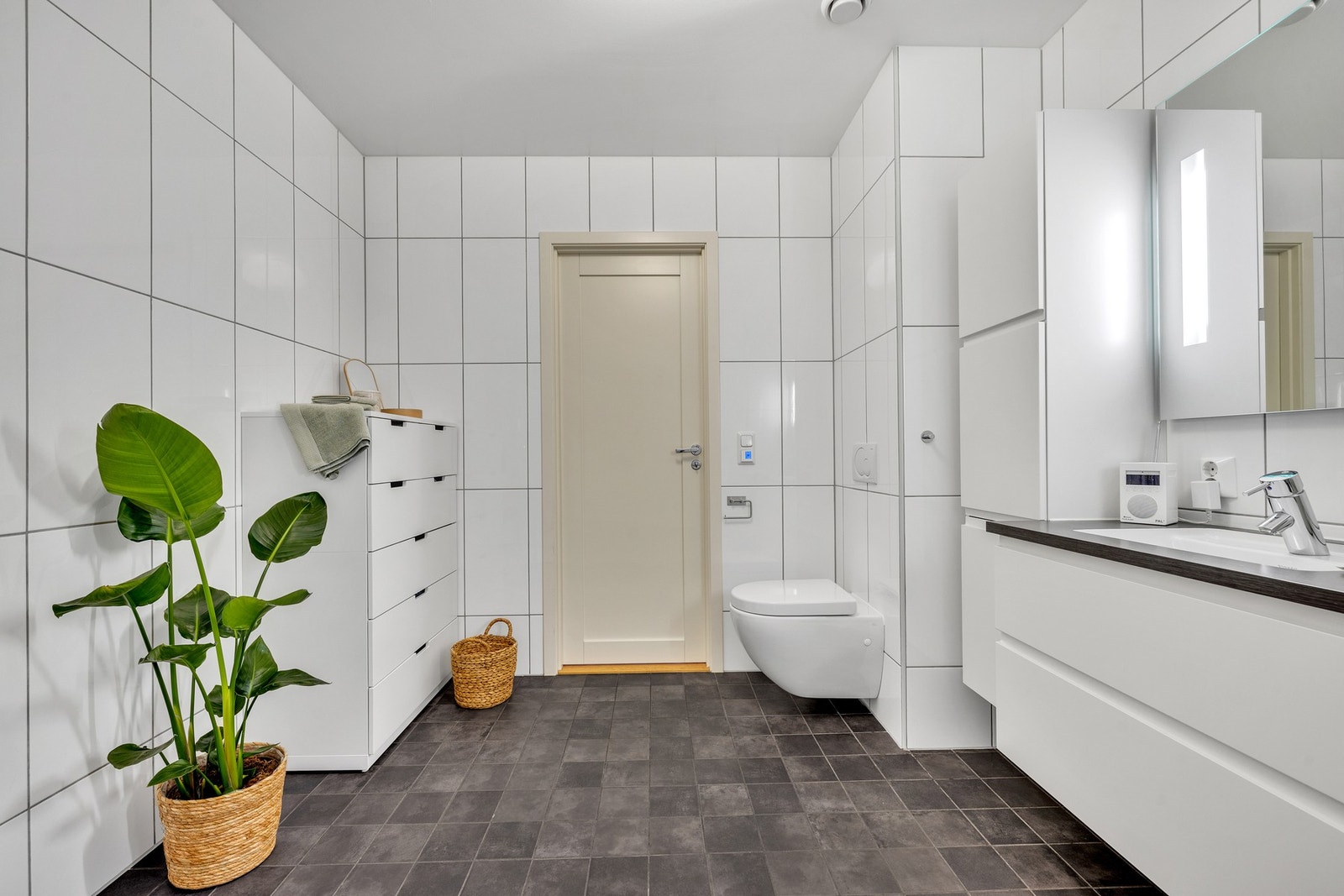 Badet er utstyrt med varmekabler i gulv, dusjkabinett, vegghengt toalett og dobbel servant. Galleribilde