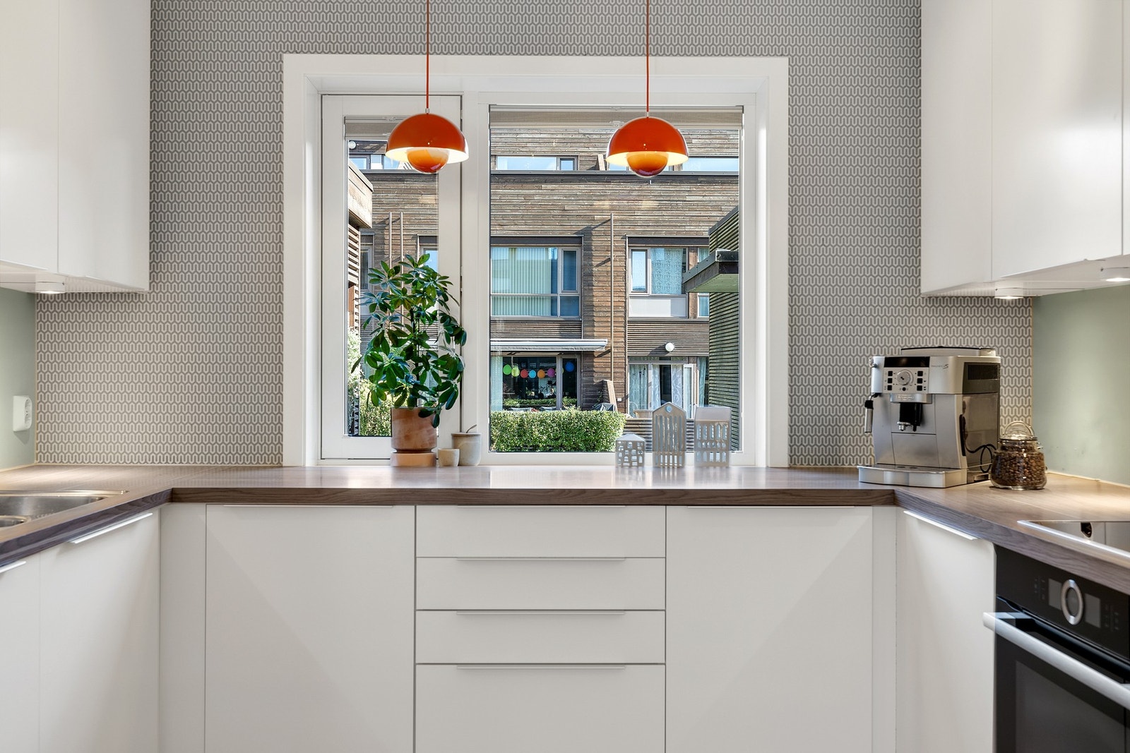 Lyst og stilrent kjøkken som har rikelig med skap- og benkeplass. Galleribilde