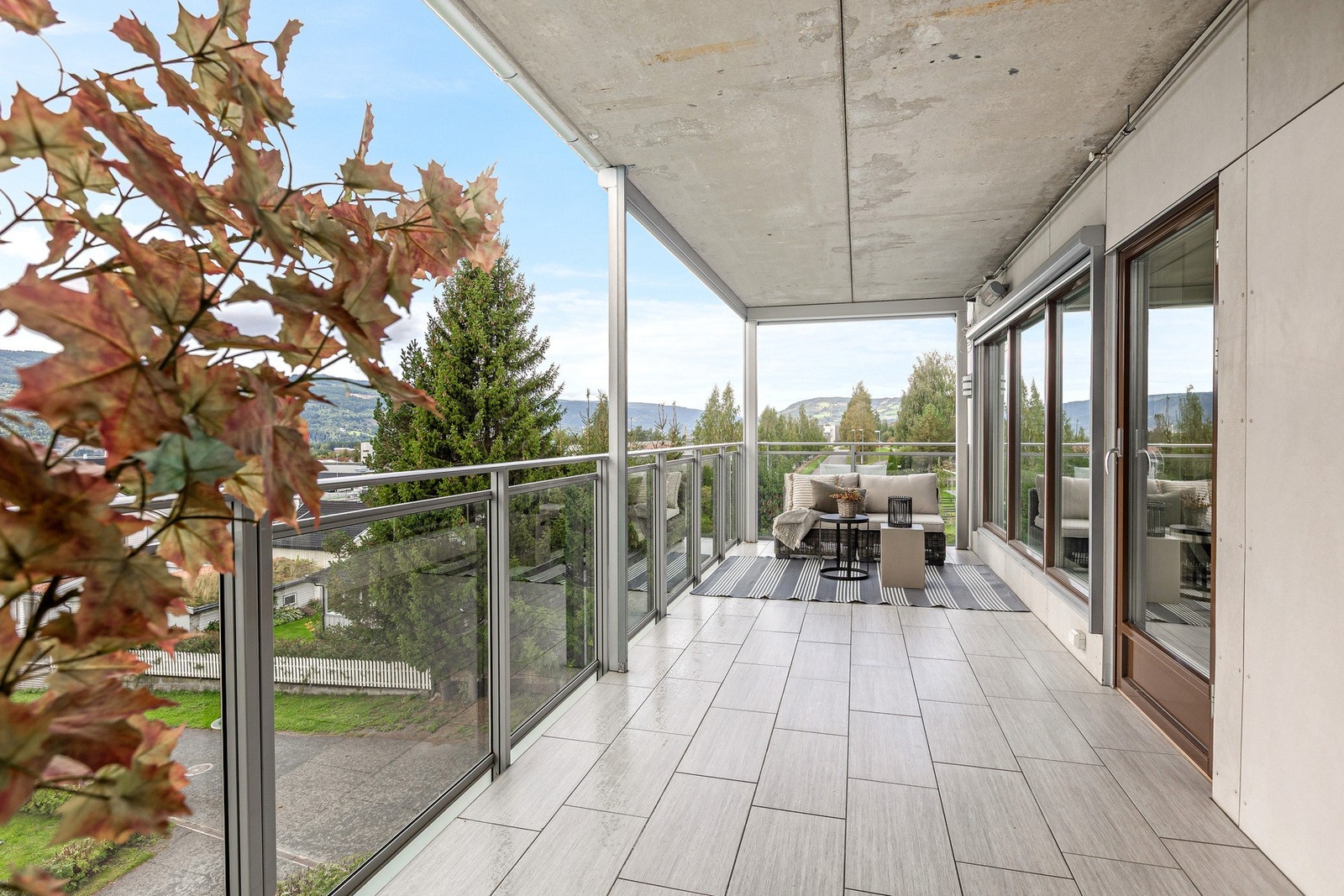 Stor, overbygget og solvendt terrasse med flislagt gulv. Galleribilde