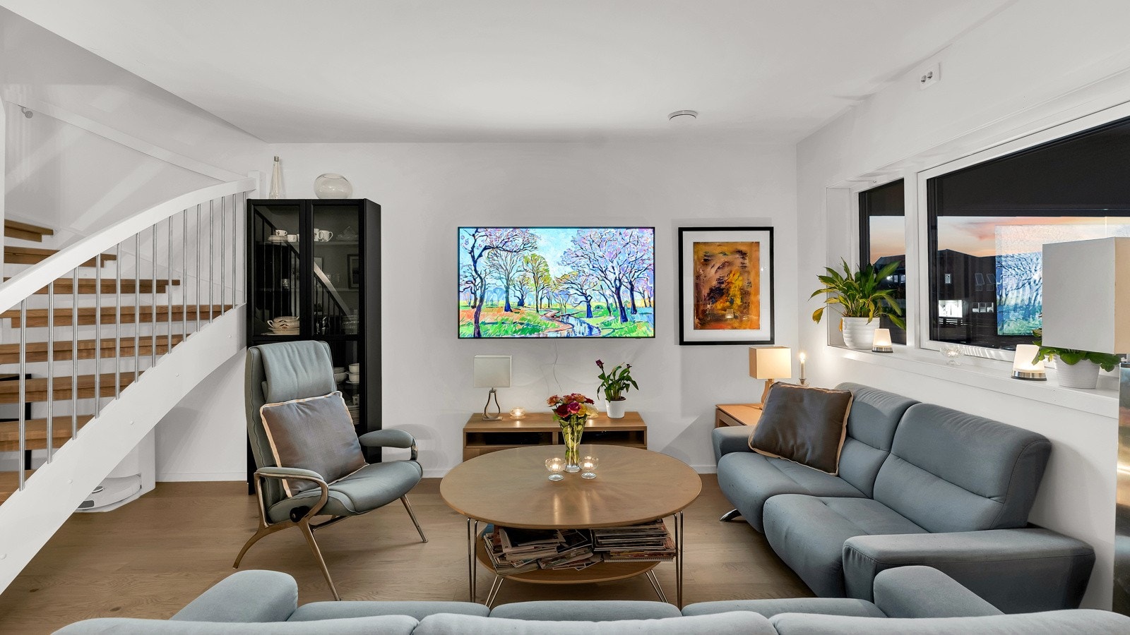 Stuen ligger i delvis åpen løsning med kjøkkenet - og i overgangen mellom stuen og kjøkkenet svinger en stilfull trapp seg opp til andre etasje. Galleribilde