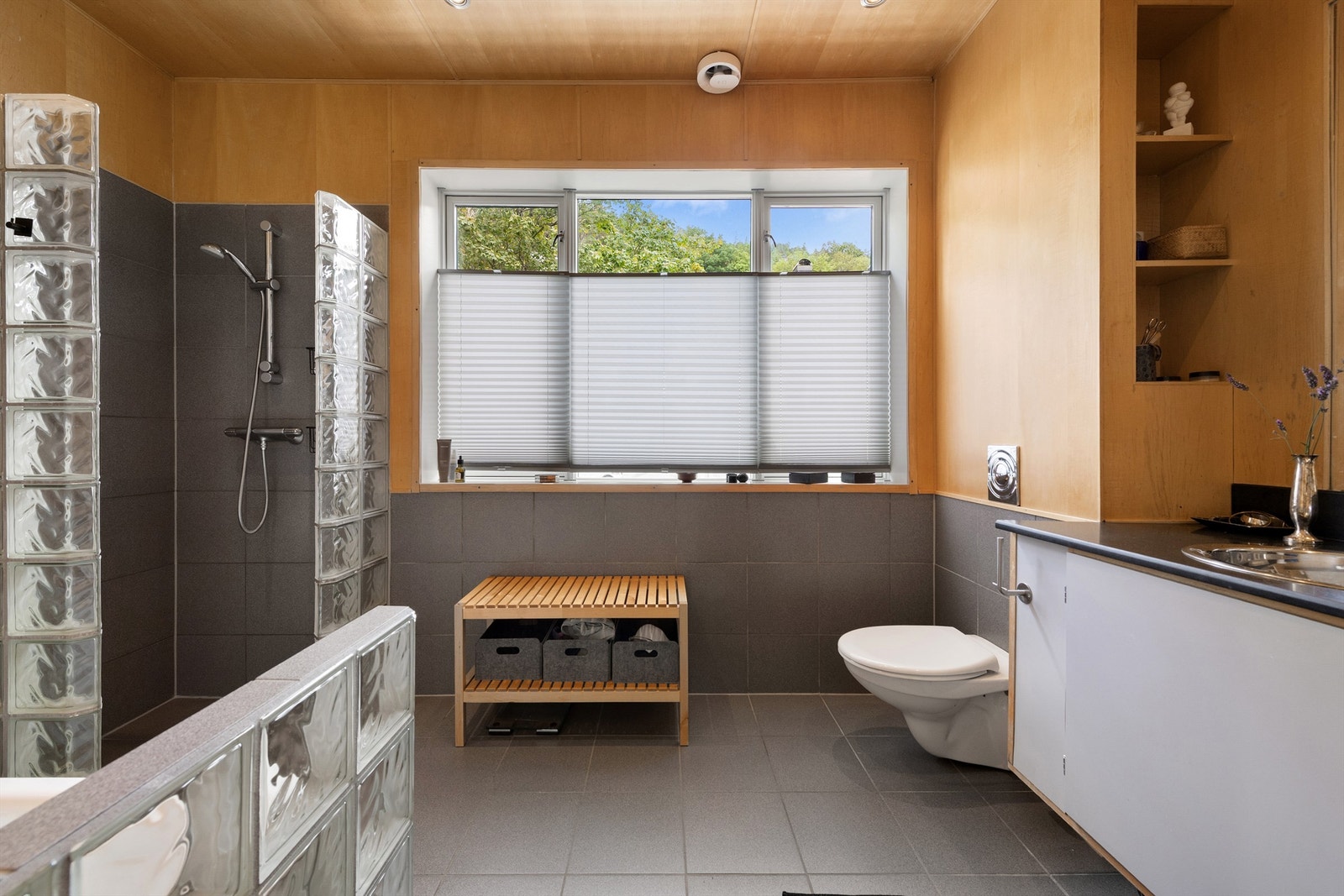 Romslig bad med dusj, badekar og vegghengt toalett. Galleribilde