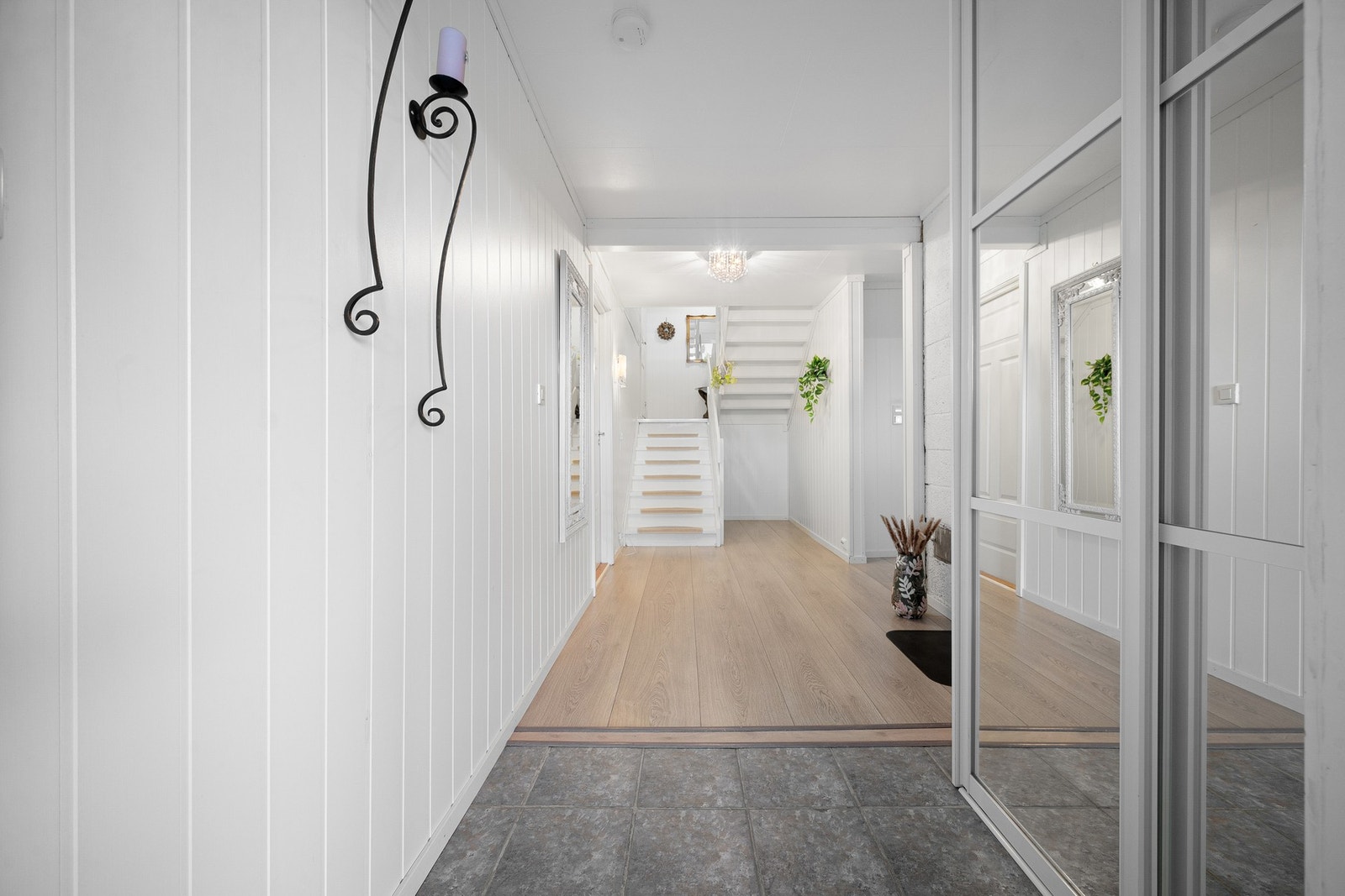 Når man kommer inn i huset så møtes man av en stor romslig hall med innebygd skyvedørsgarderobe Galleribilde