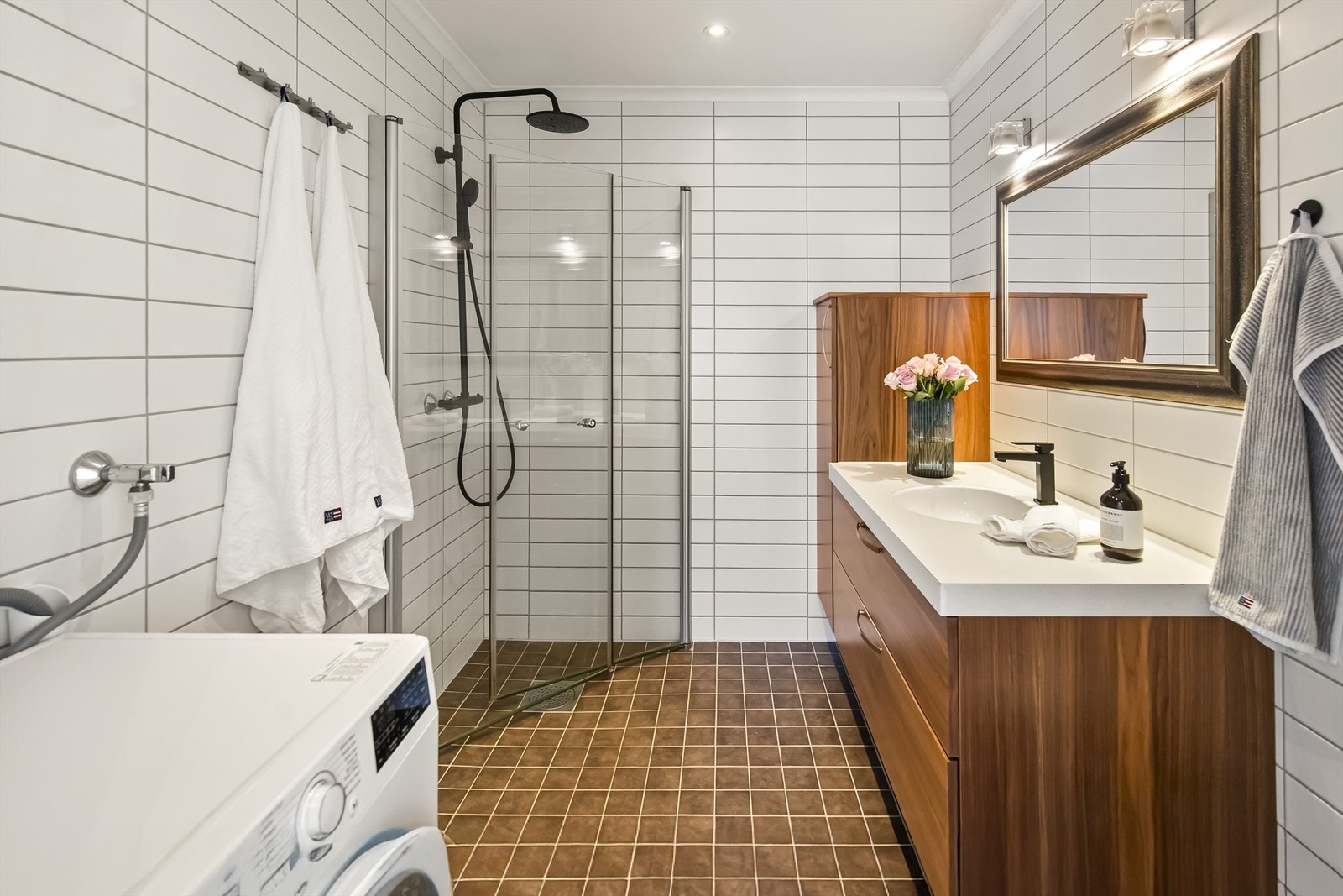 Badet i 2. etasje er innredet med dusj, vegghengt toalettt, servant i innredning med sideskap samt opplegg til vaskemaskin Galleribilde