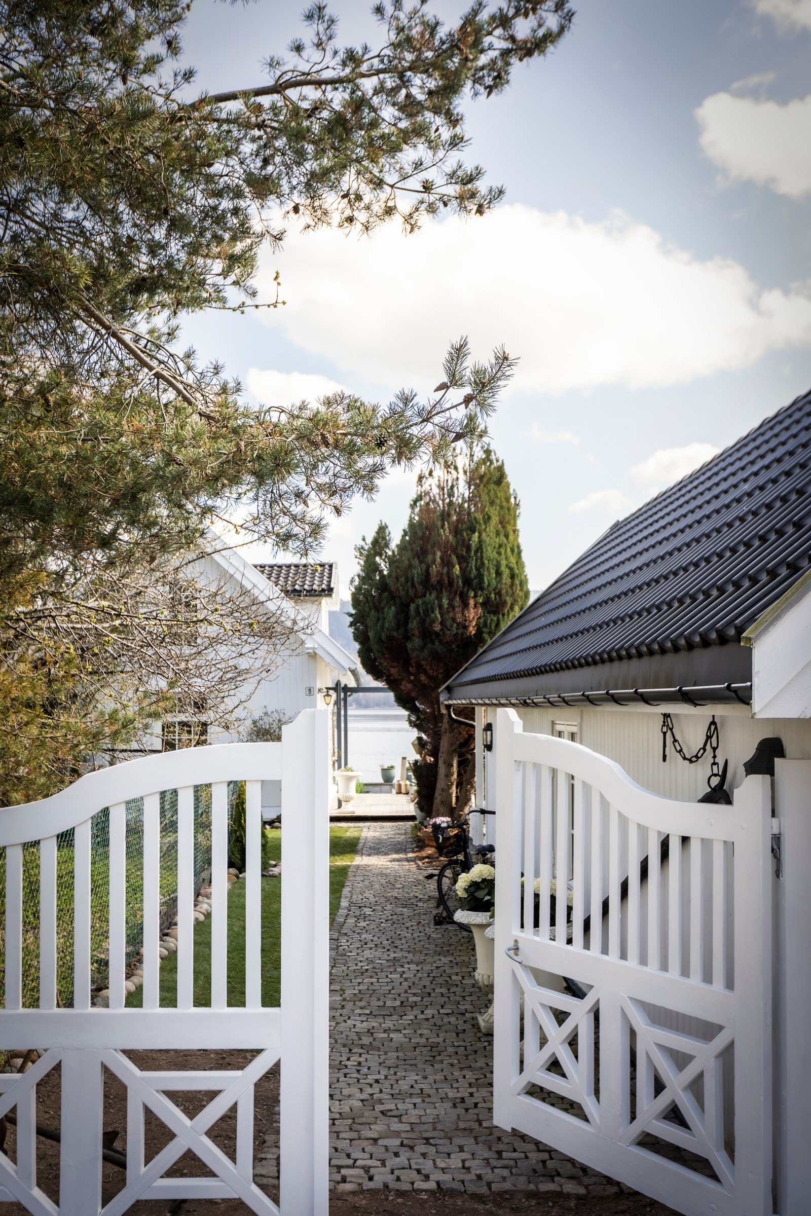 Et sjarmerende inngangsparti med teglsteinsbelagt sti og en sjarmerende port ønsker deg velkommen til eiendommen. Galleribilde