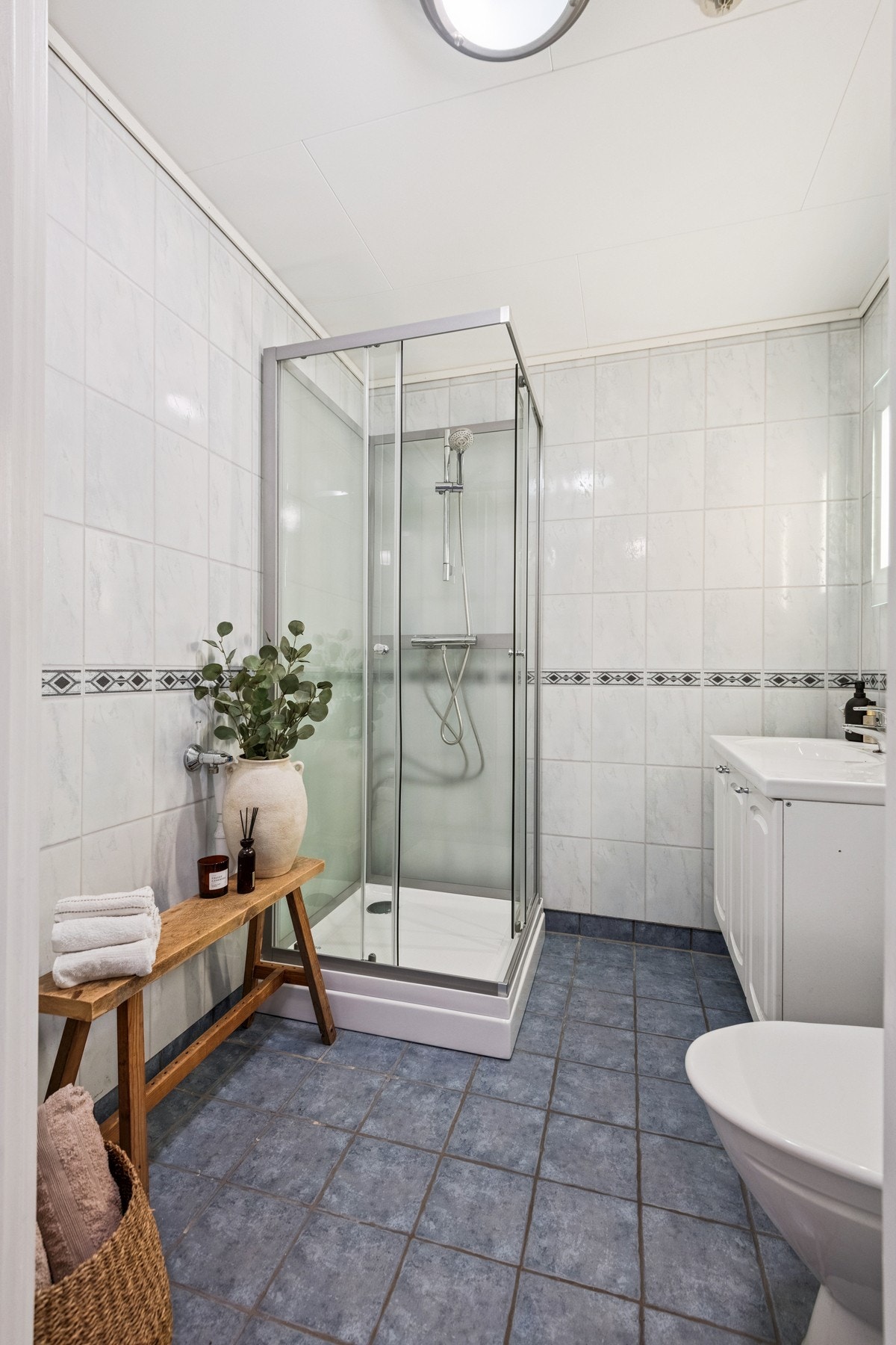Flislagt bad med varmekabler i gulv. Det er opplegg for vaskemaskin på badet. Galleribilde