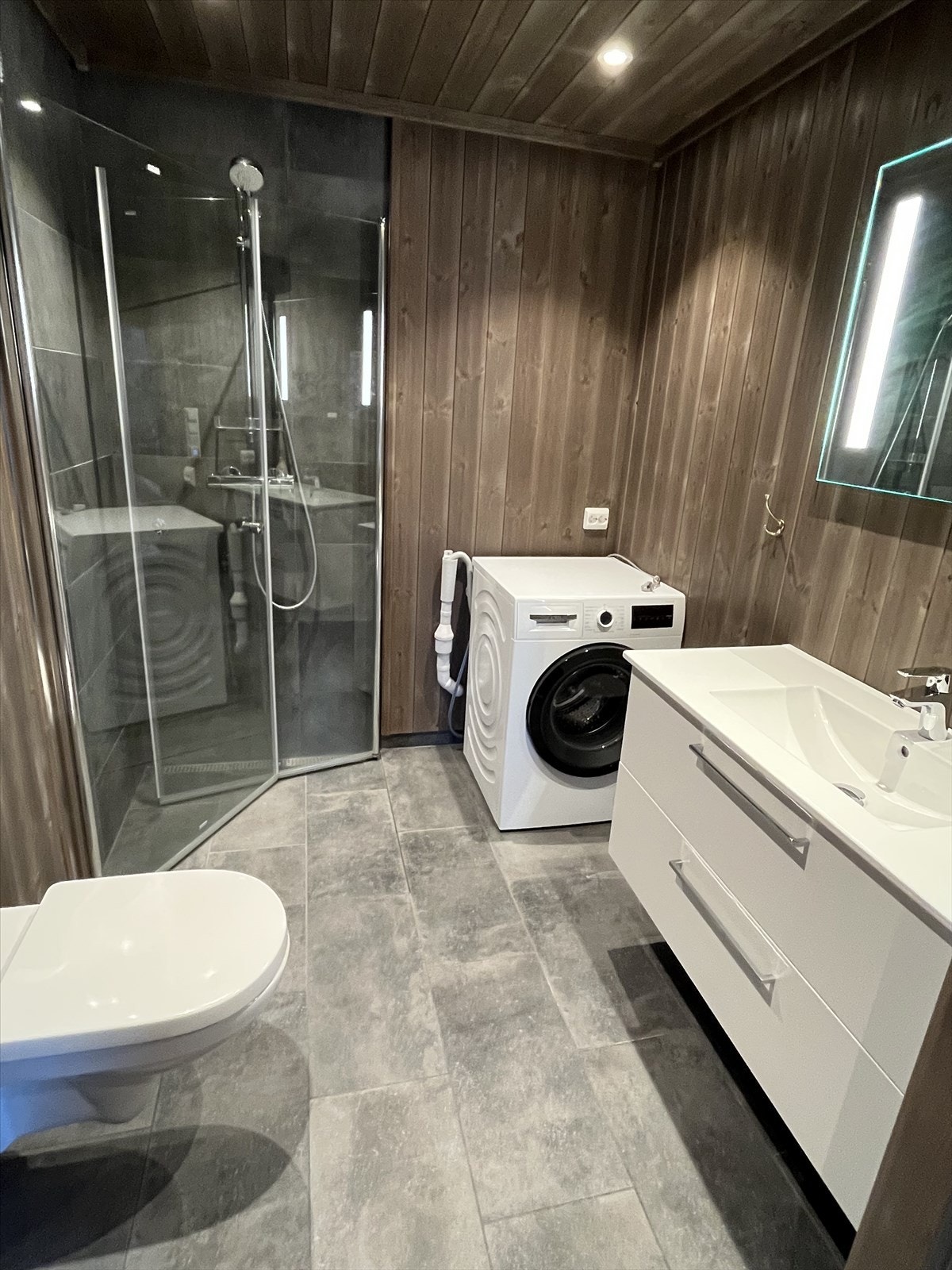 Det er to delikate baderom i hytta, begge med fliser på gulv og beiset, panelte vegger og himling. Bad 1 med opplegg for vaskemaskin. Galleribilde