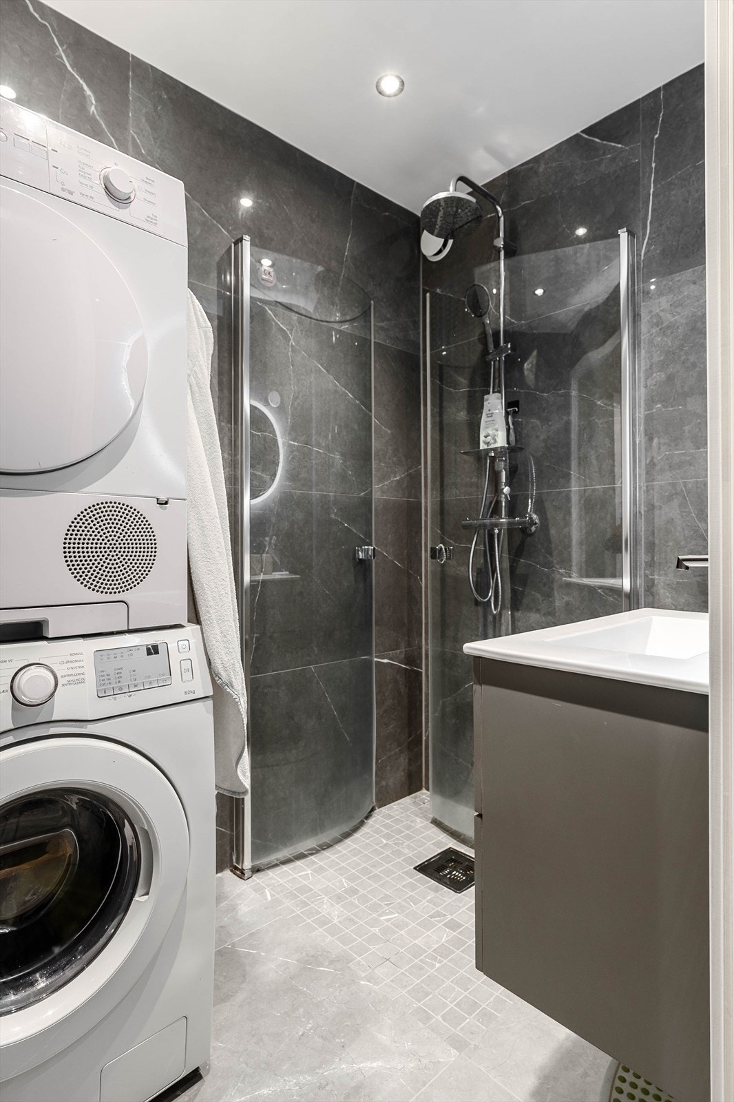 Badet er innredet med innfellbare dusjhjørner, servantinnredning og opplegg for vaskemaskin. Galleribilde