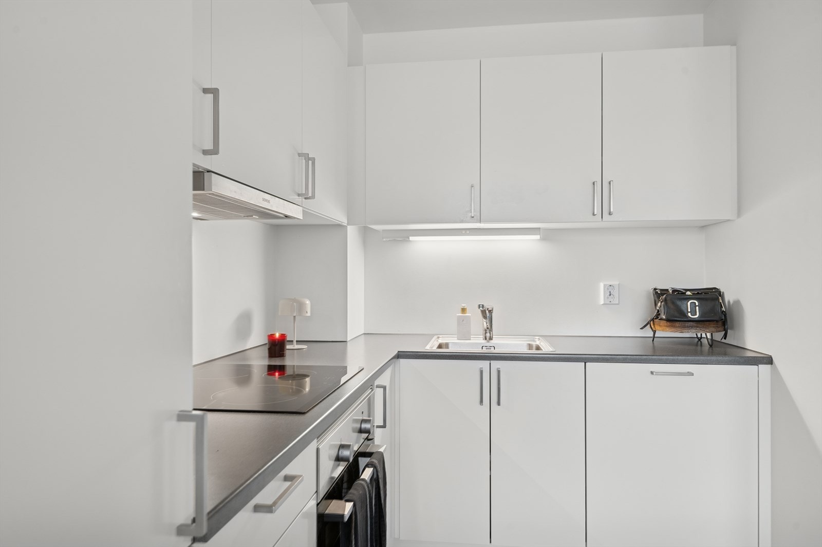 Det er belysning over benkeplaten som gir godt arbeidslys. Kjøkkenventilator med avtrekk ut. Galleribilde