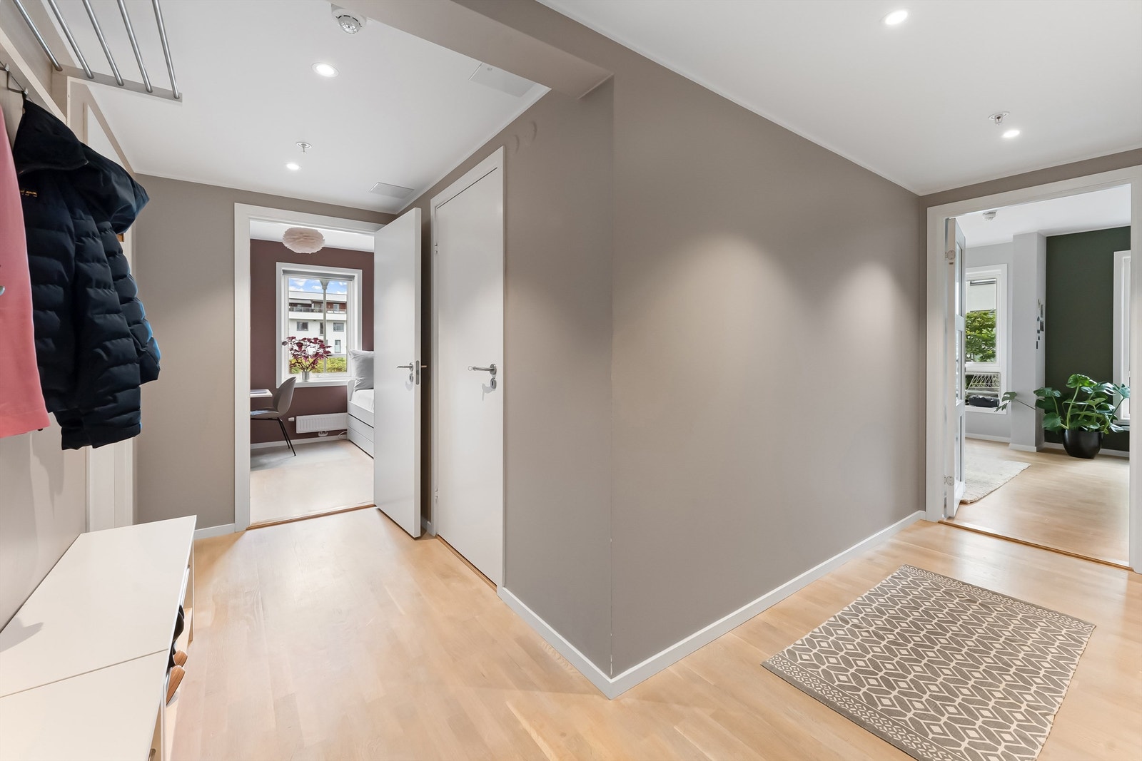 Åpen og luftig hall med downlights. Gjennomtenkt planløsning med alle soverom plassert i den ene siden, mens stue og kjøkken er plassert i den andre Galleribilde