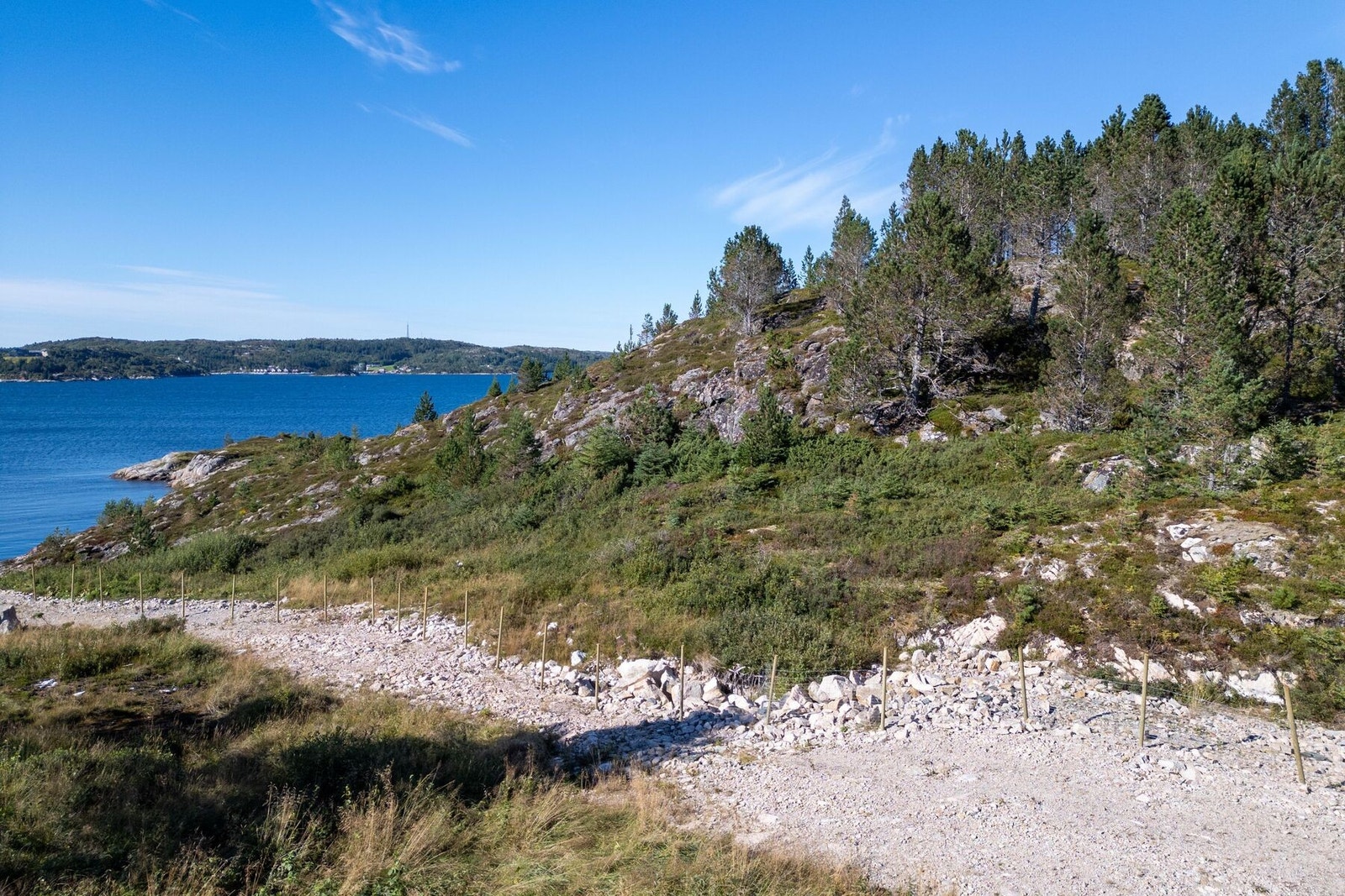 Tomten ligger nederst mot sjøen, uten andre tomter fremfor seg. Galleribilde